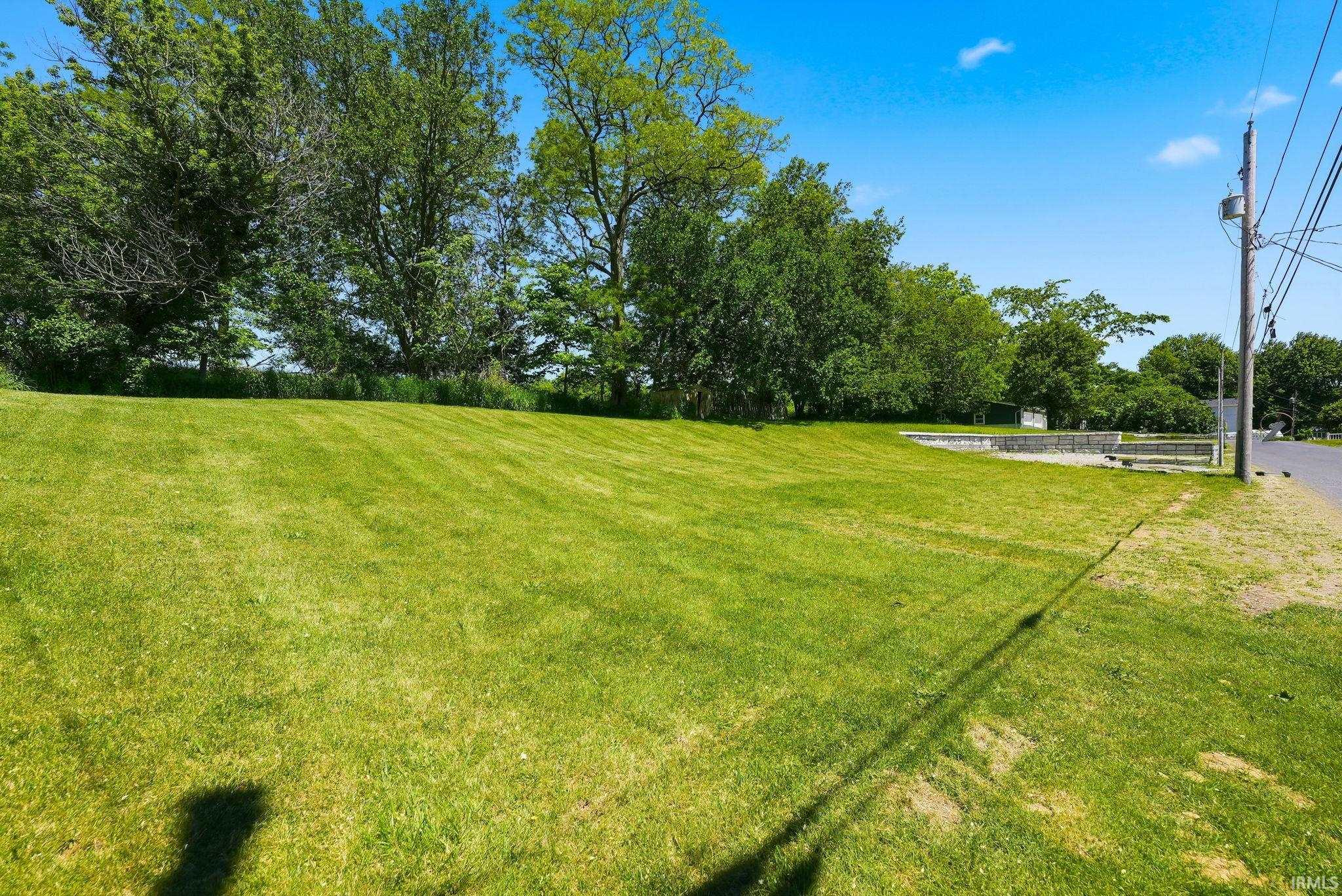 Expansive grass lot bordered by mature trees