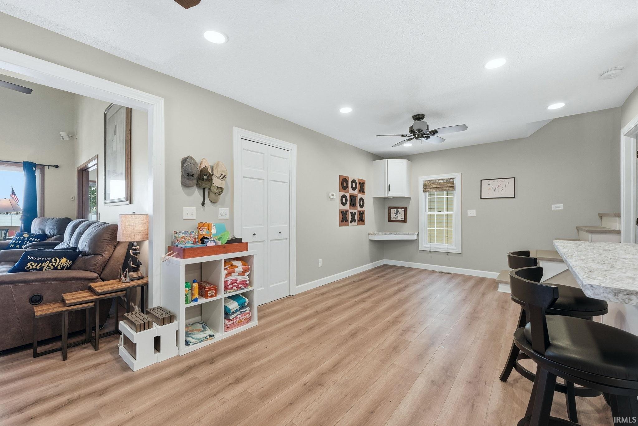 Spacious room with wood-finish flooring, recessed lighting, and a ceiling fan