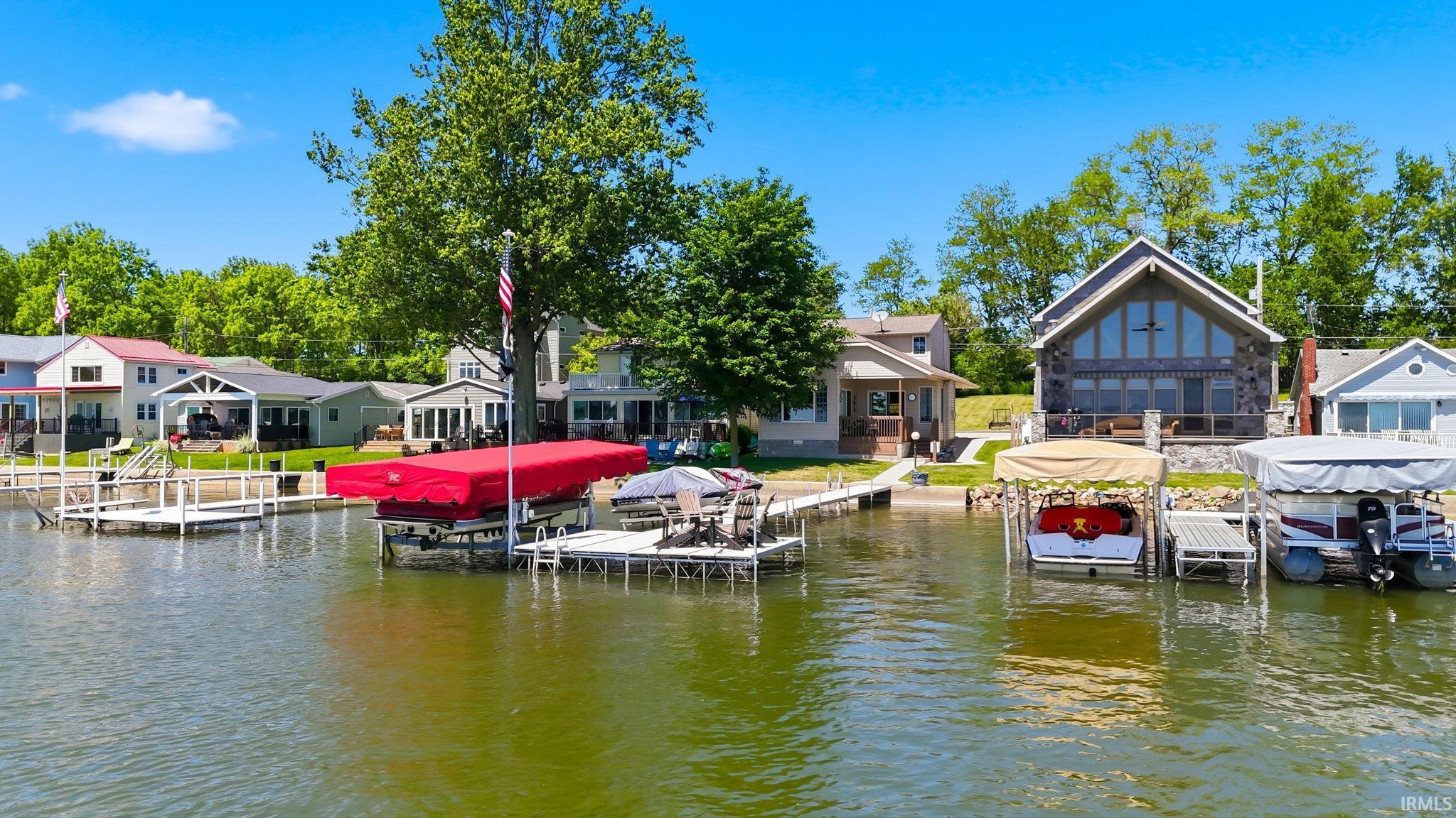 Waterfront property featuring multiple private docks and lush surrounding trees