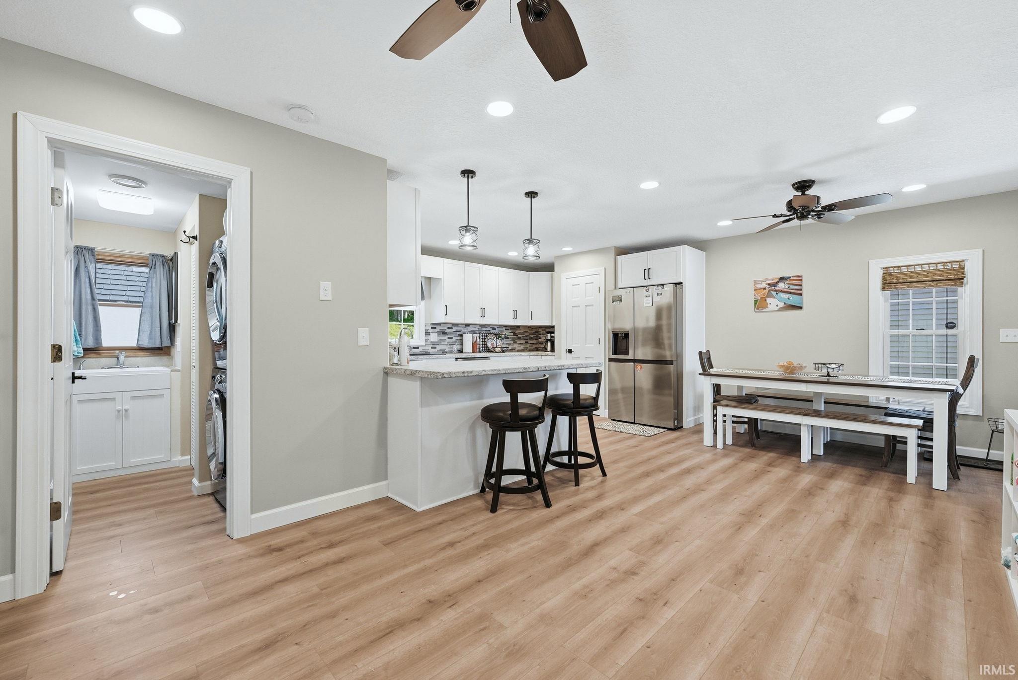 Open-concept living area featuring wood-finish flooring, recessed lighting, and ceiling fans