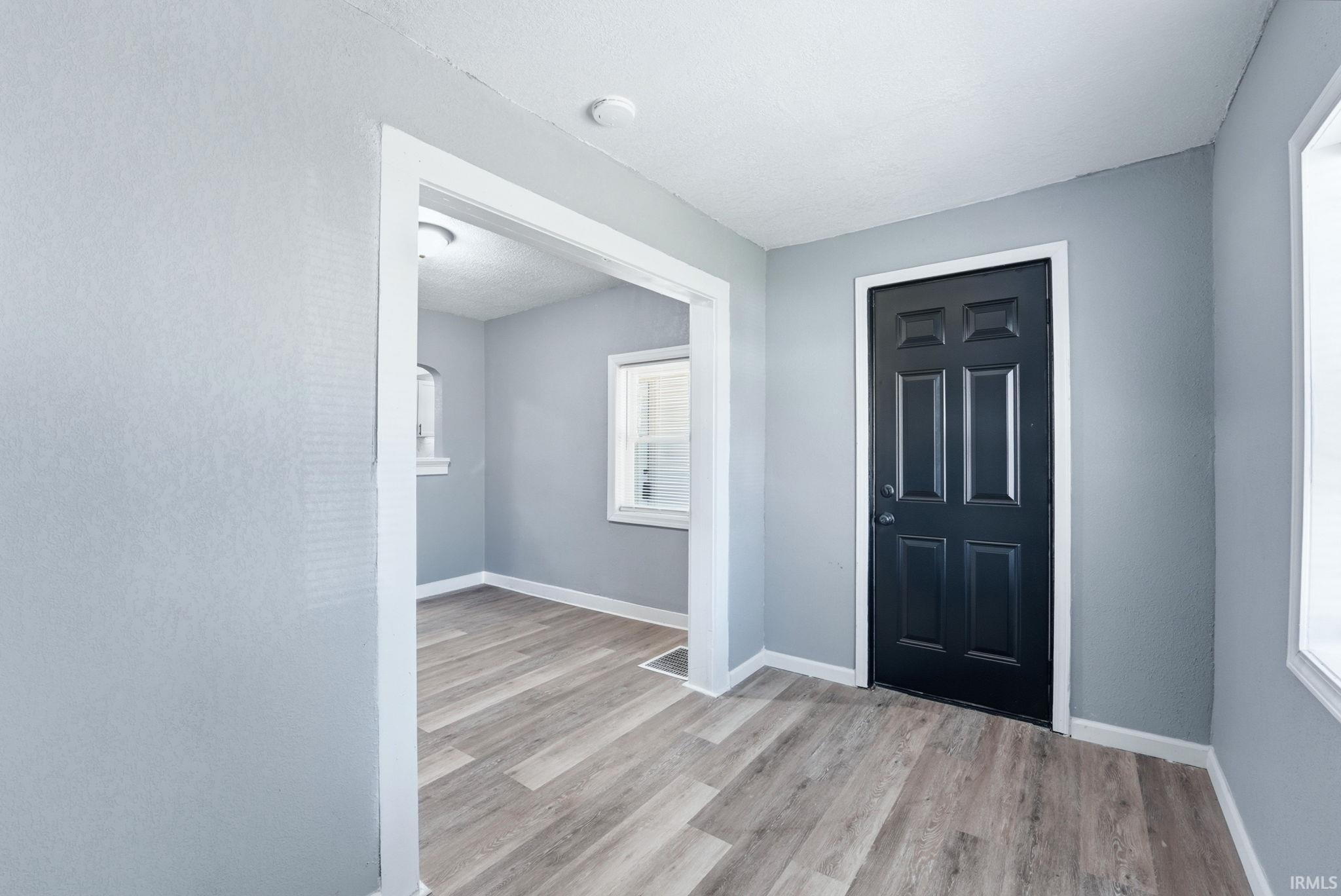Light wood-finish flooring throughout, complemented by light gray walls