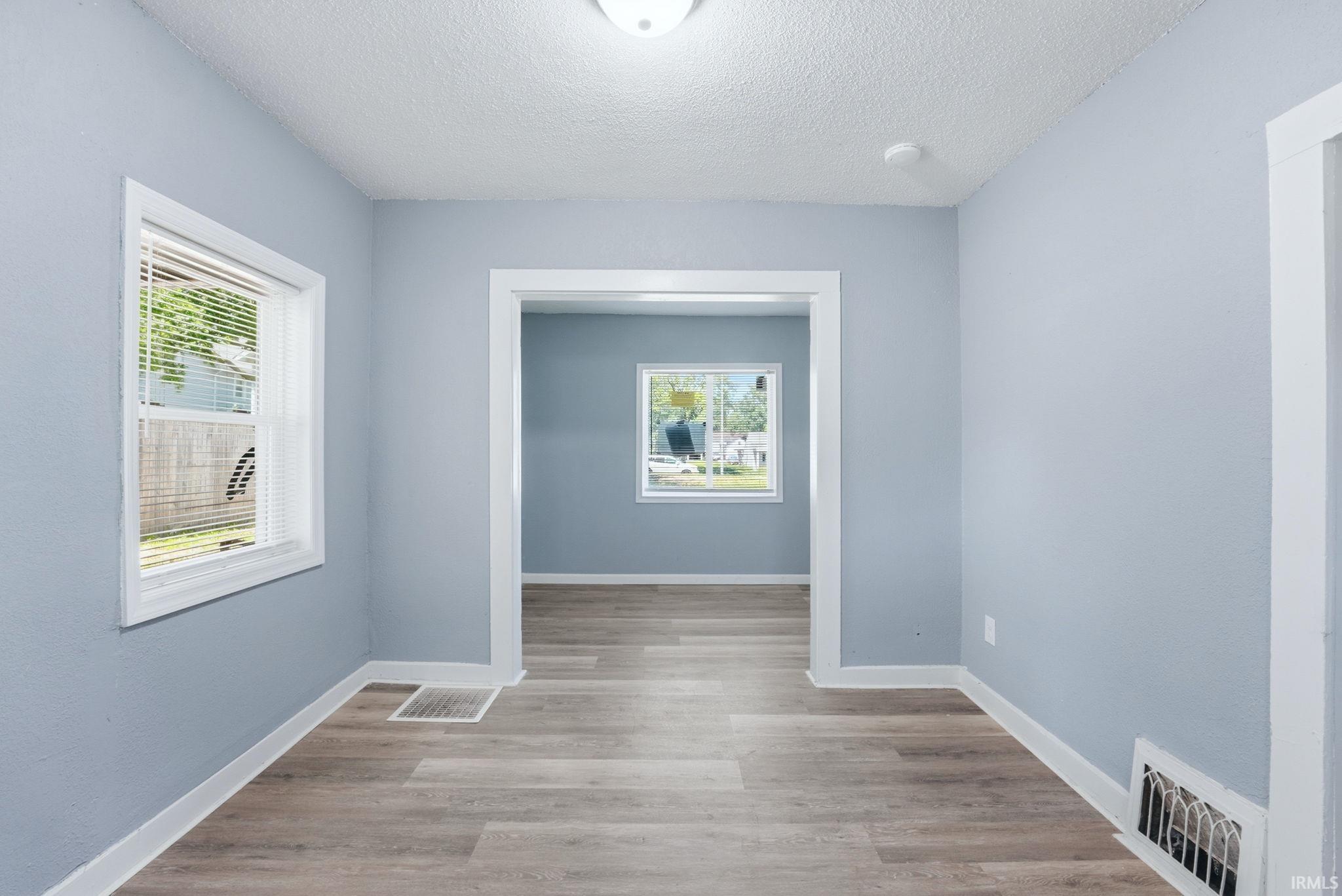 Interior room featuring wood-finish flooring, light blue walls, and white trim