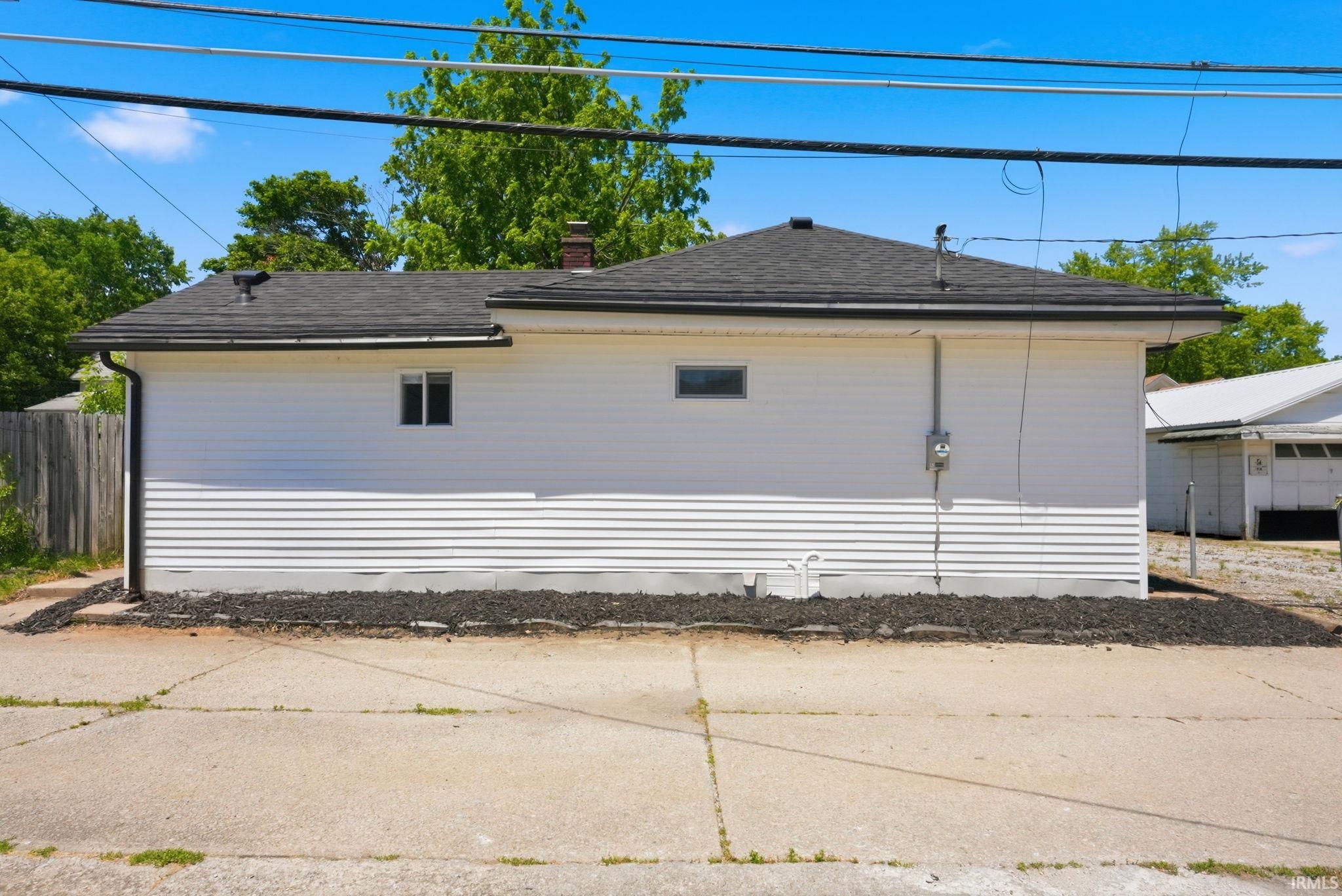 White siding exterior with a dark shingle roof and contrasting dark gutters
