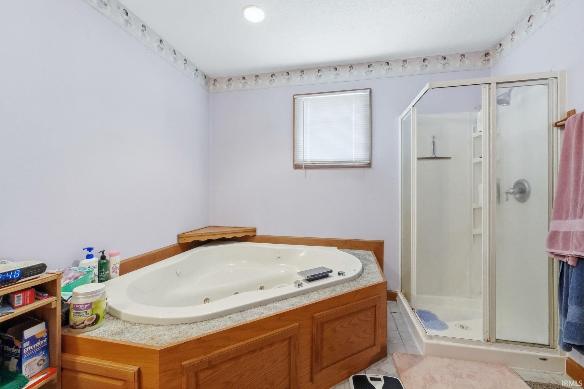 Corner jetted tub with wood-finish surround and integrated corner shelf