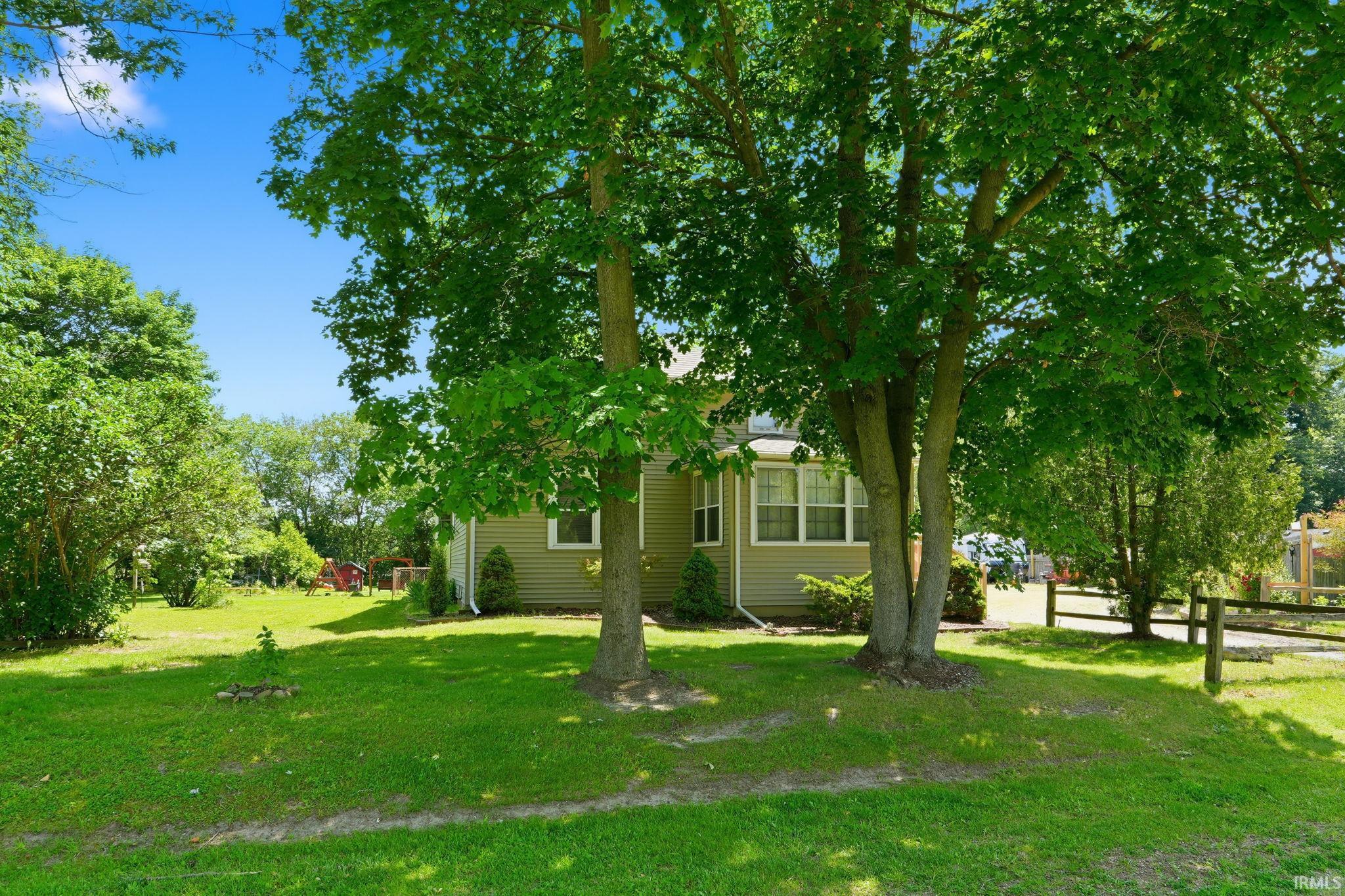 Expansive green lawn with mature trees providing ample shade
