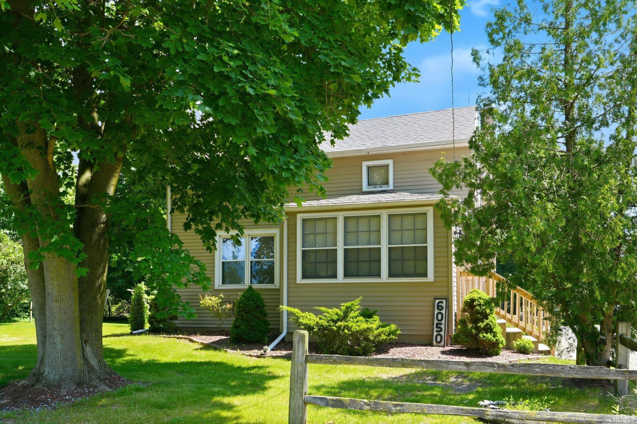 Two-story residence featuring light brown siding and white trim