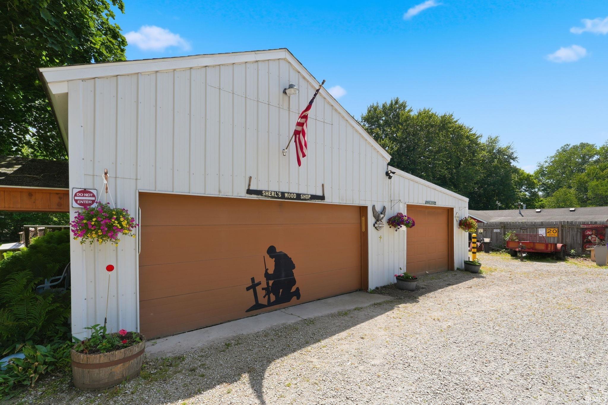 Two-car garage structure featuring vertical white siding and two distinct garage doors