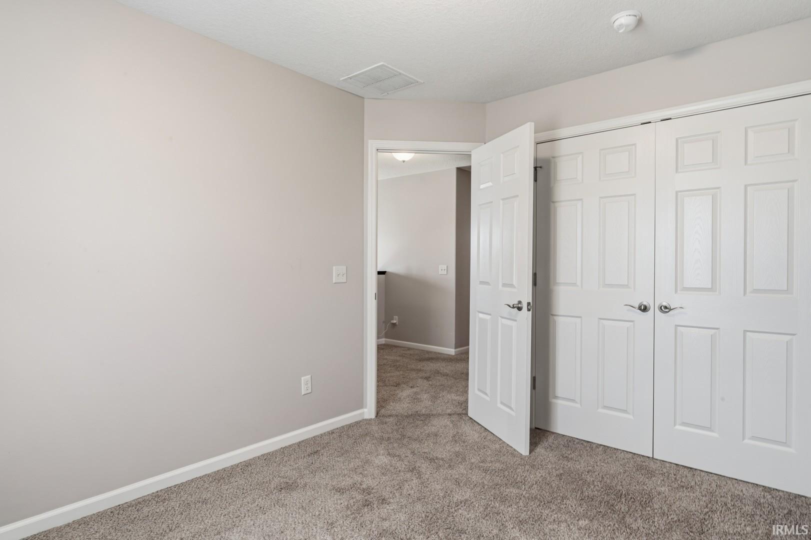Soft gray wall paint with white trim, complementing the plush gray carpet