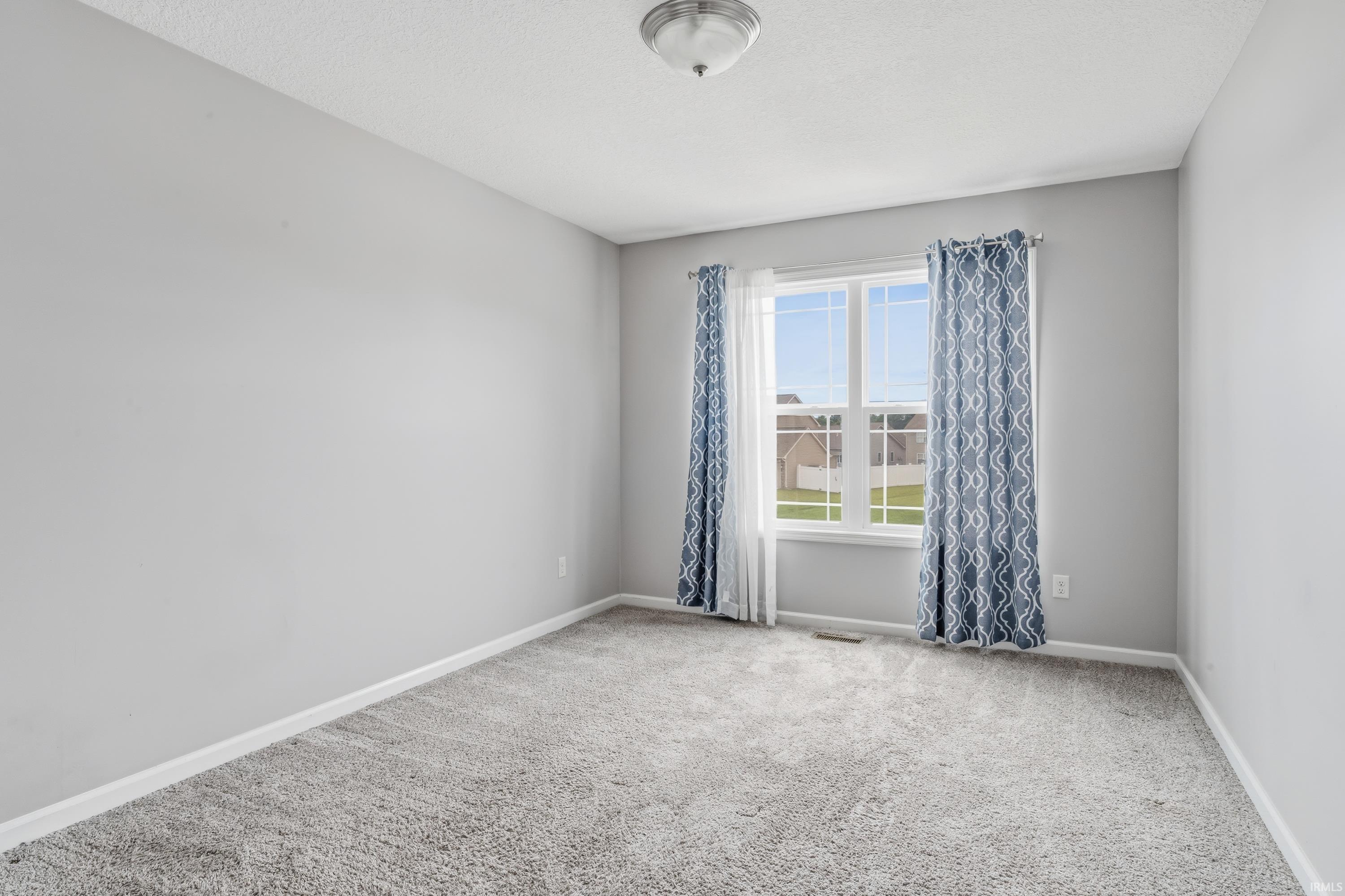 Room featuring light gray wall paint, gray carpet, and white trim