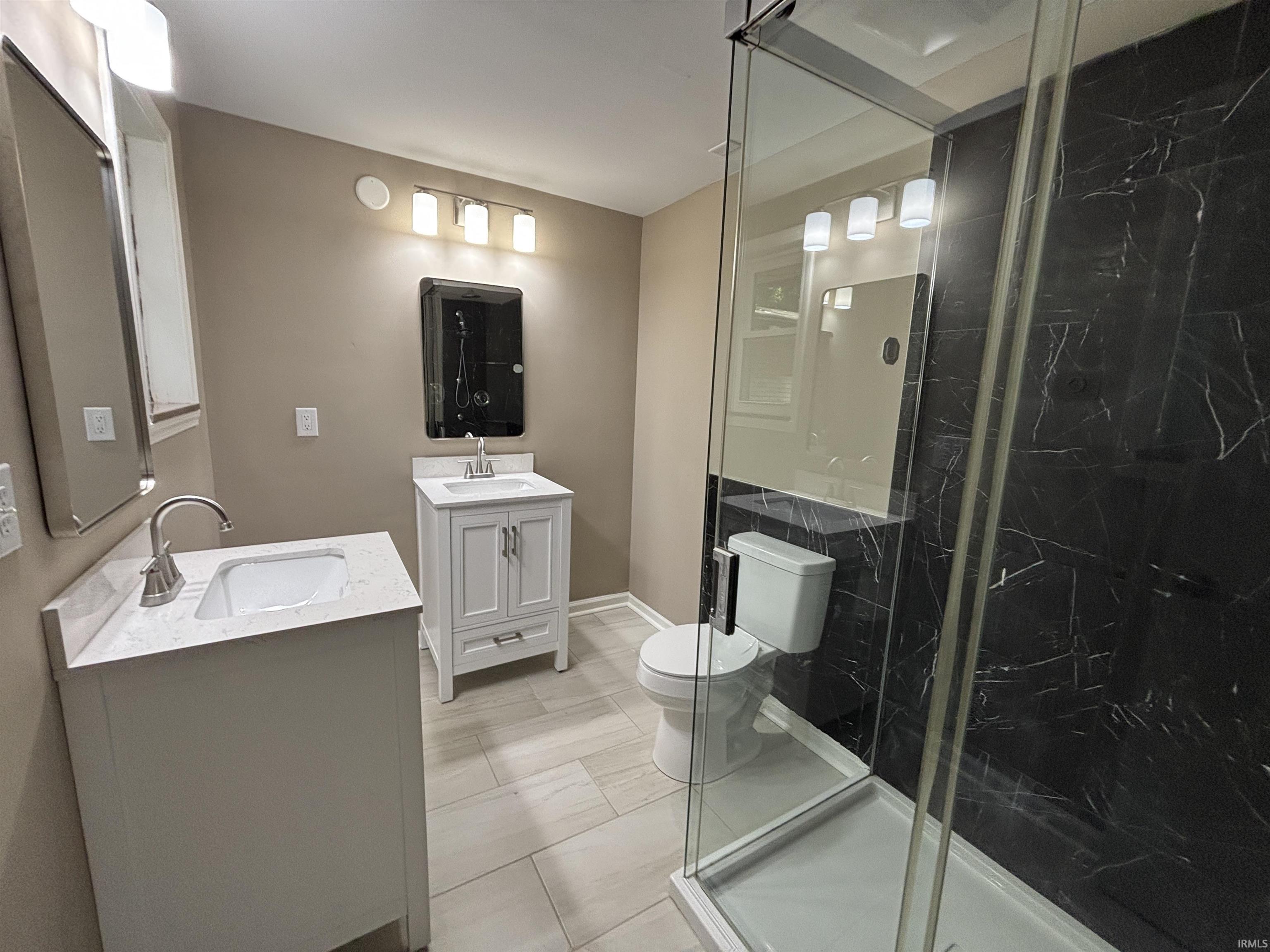 Contemporary bathroom featuring a glass-enclosed shower with black marble-effect wall tiles