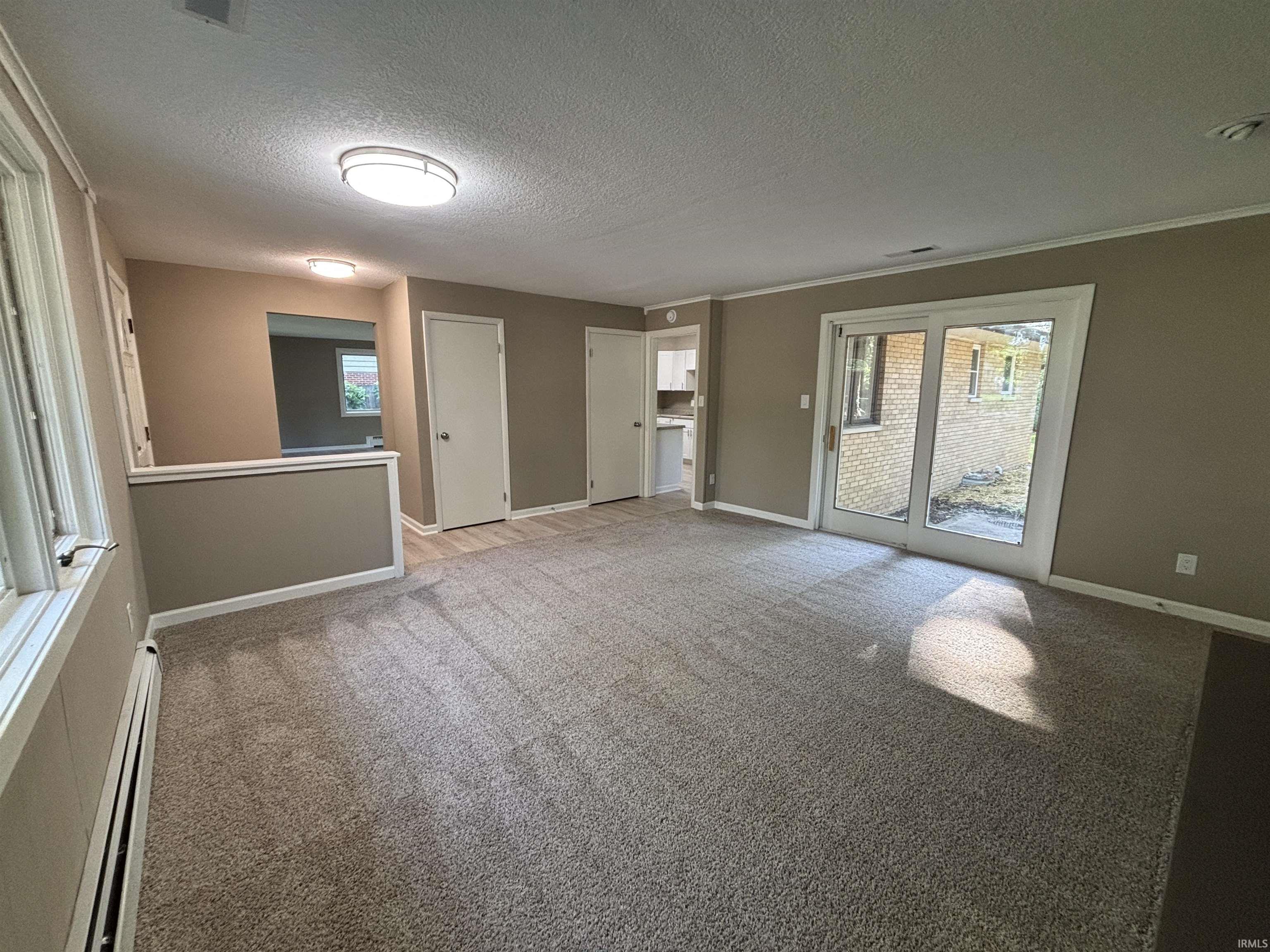 Carpeted living area featuring neutral wall tones and a sliding glass door