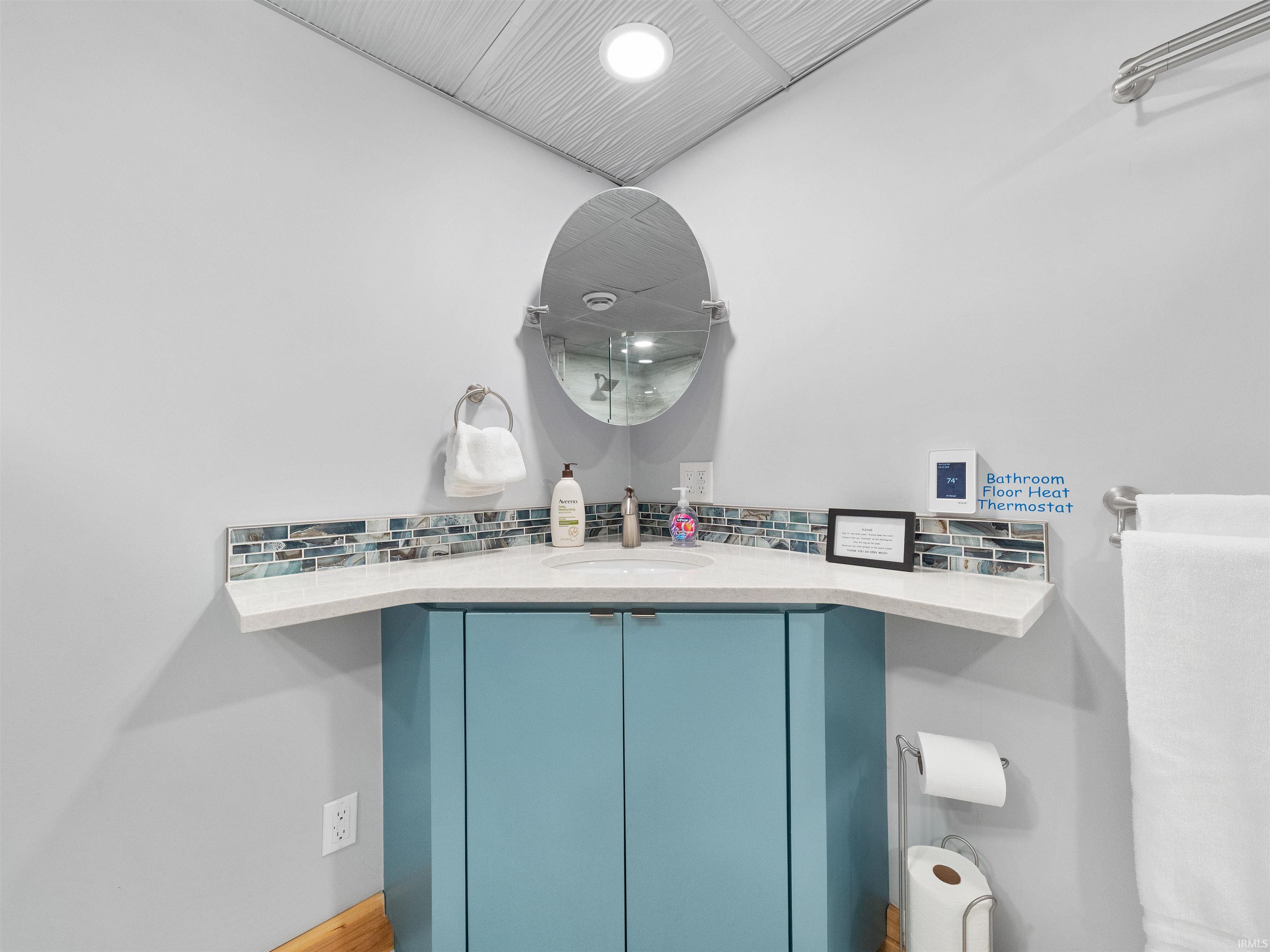 Bathroom vanity featuring a quartz countertop, integrated sink, and blue cabinetry