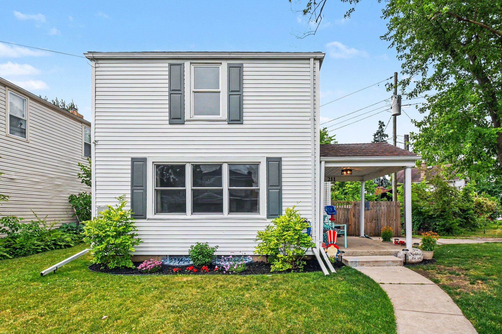 Two-story residence featuring white siding and dark shutters