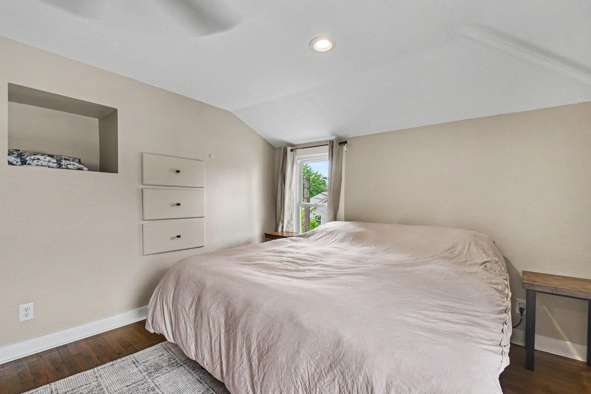 Room featuring wood-finish flooring, recessed lighting, and a window with natural light