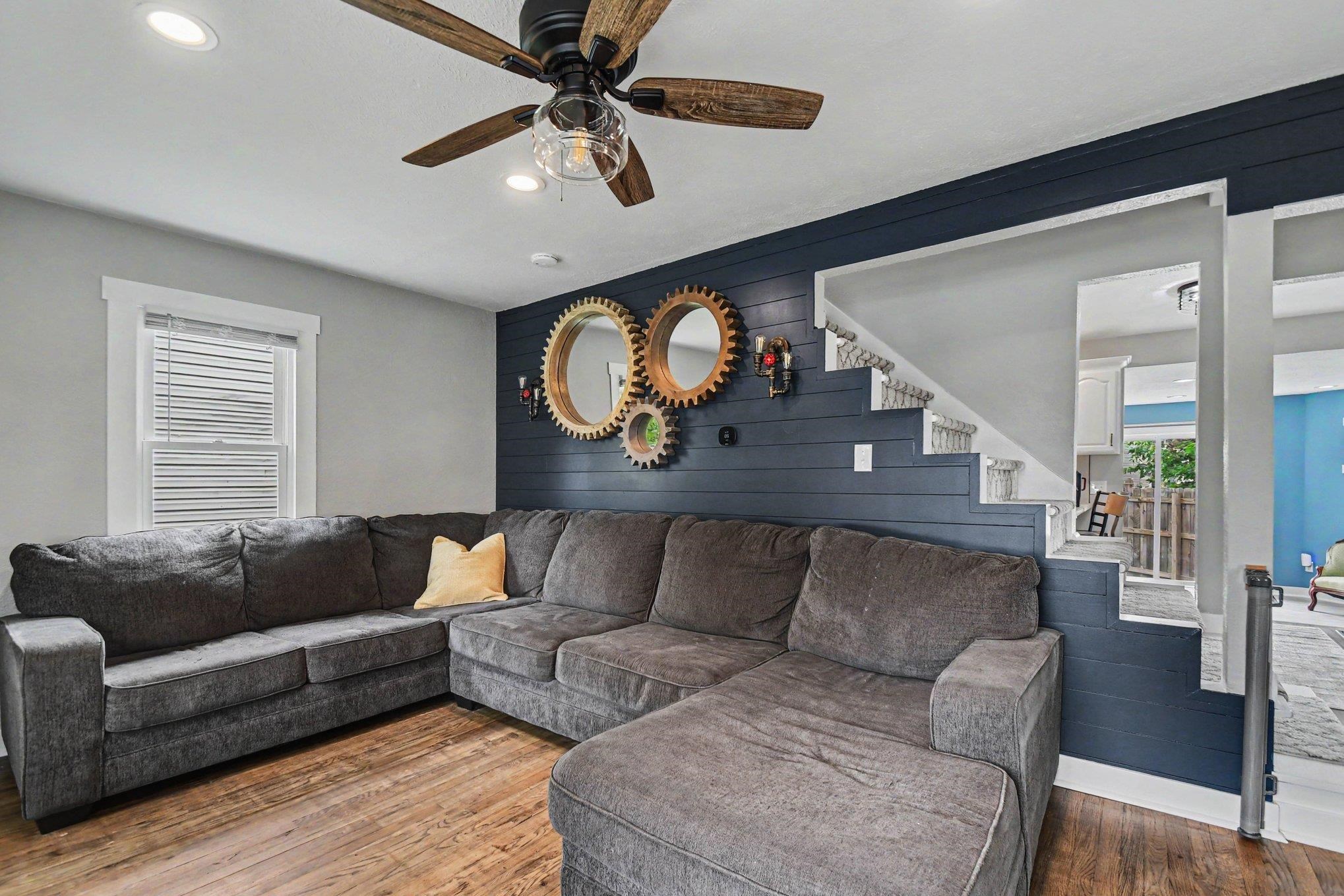 Living area featuring wood-finish flooring, recessed lighting, and a ceiling fan with light fixture