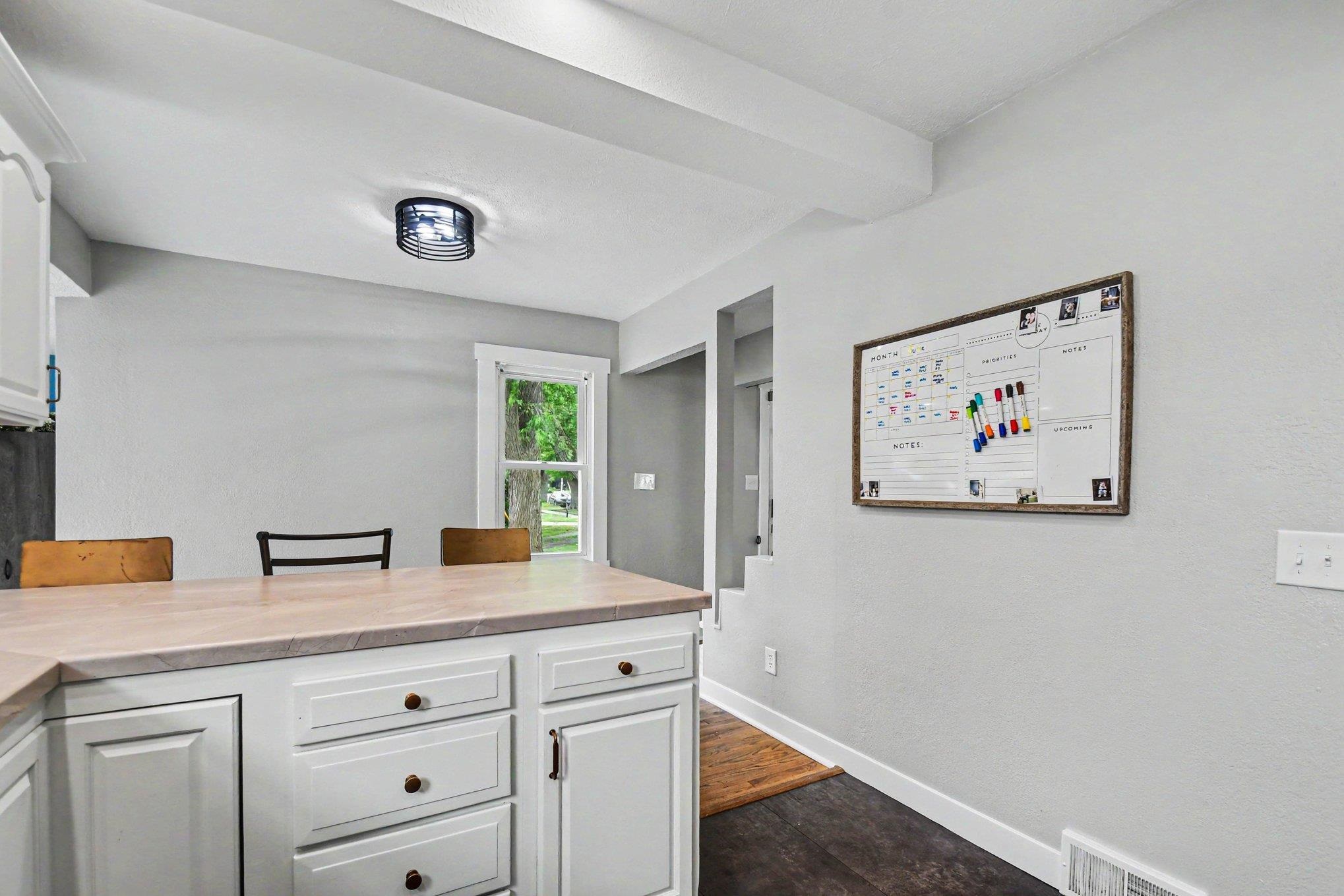 Light-colored countertop with white cabinetry and dark hardware