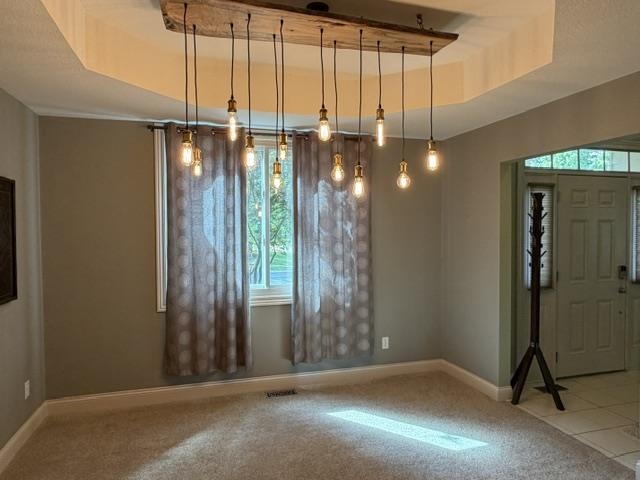 Recessed ceiling featuring a multi-bulb chandelier with exposed filaments