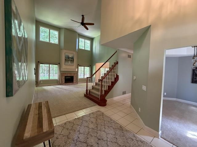 Two-story living area with a vaulted ceiling, brick fireplace, and upper and lower windows