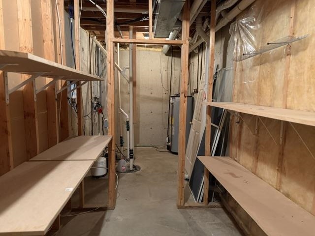 Unfinished basement area featuring exposed wood framing, concrete flooring, and substantial built-in shelving