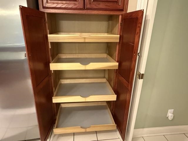 Built-in pantry cabinet featuring rich wood-finish doors and multiple pull-out storage shelves