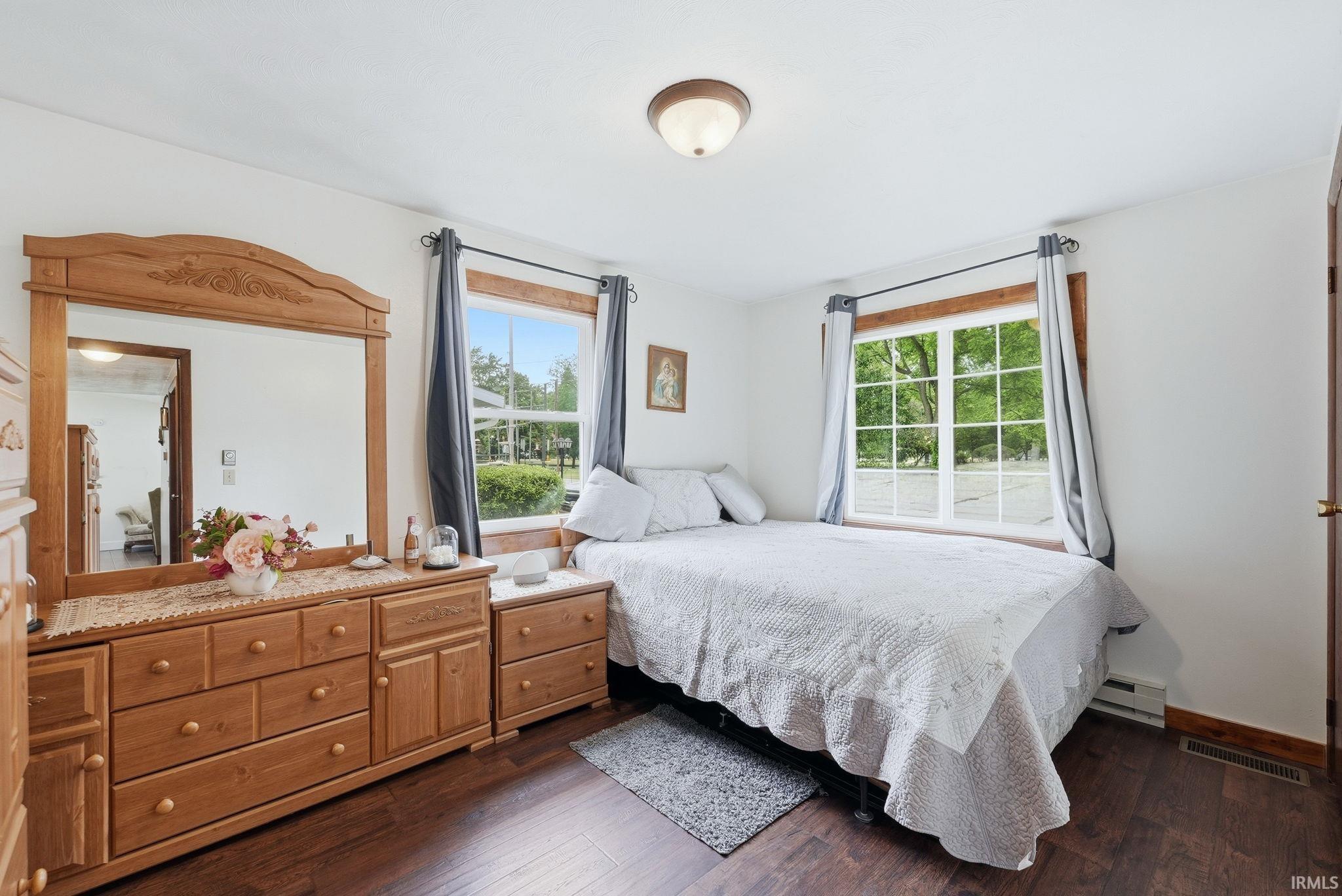 Bright interior room featuring wood-finish flooring, white walls, and a ceiling-mounted light fixture