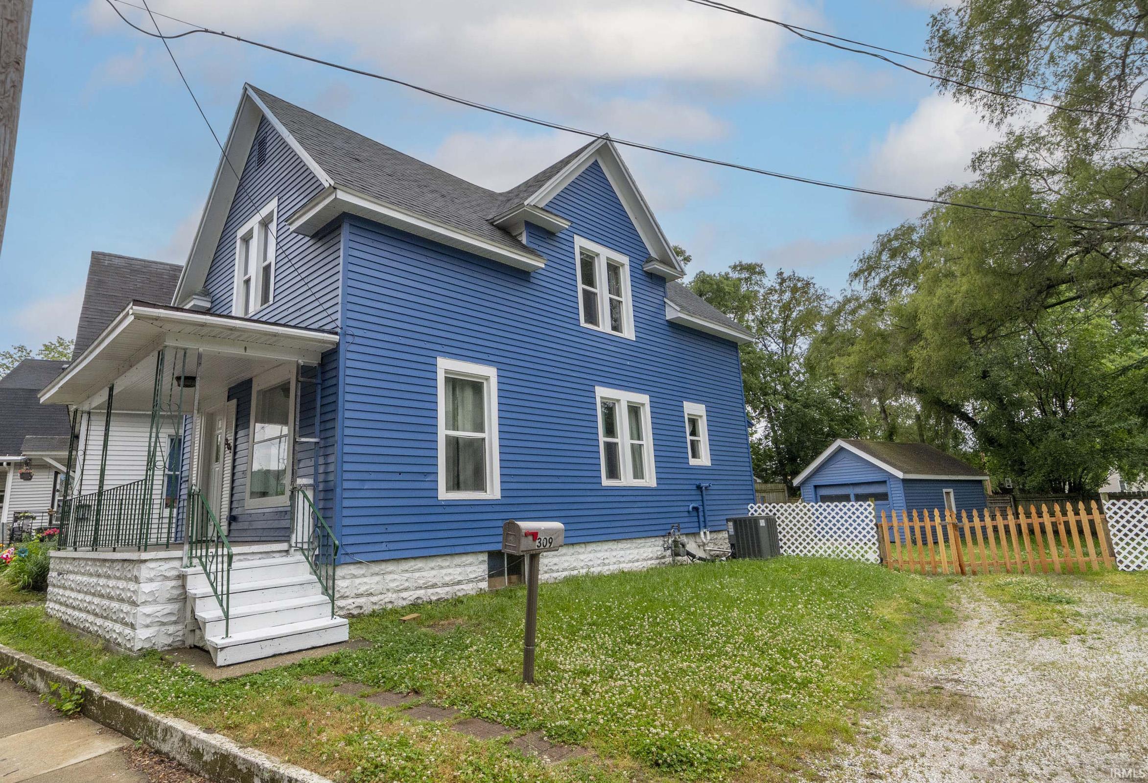 Blue siding exterior featuring a covered front porch with white railings and steps