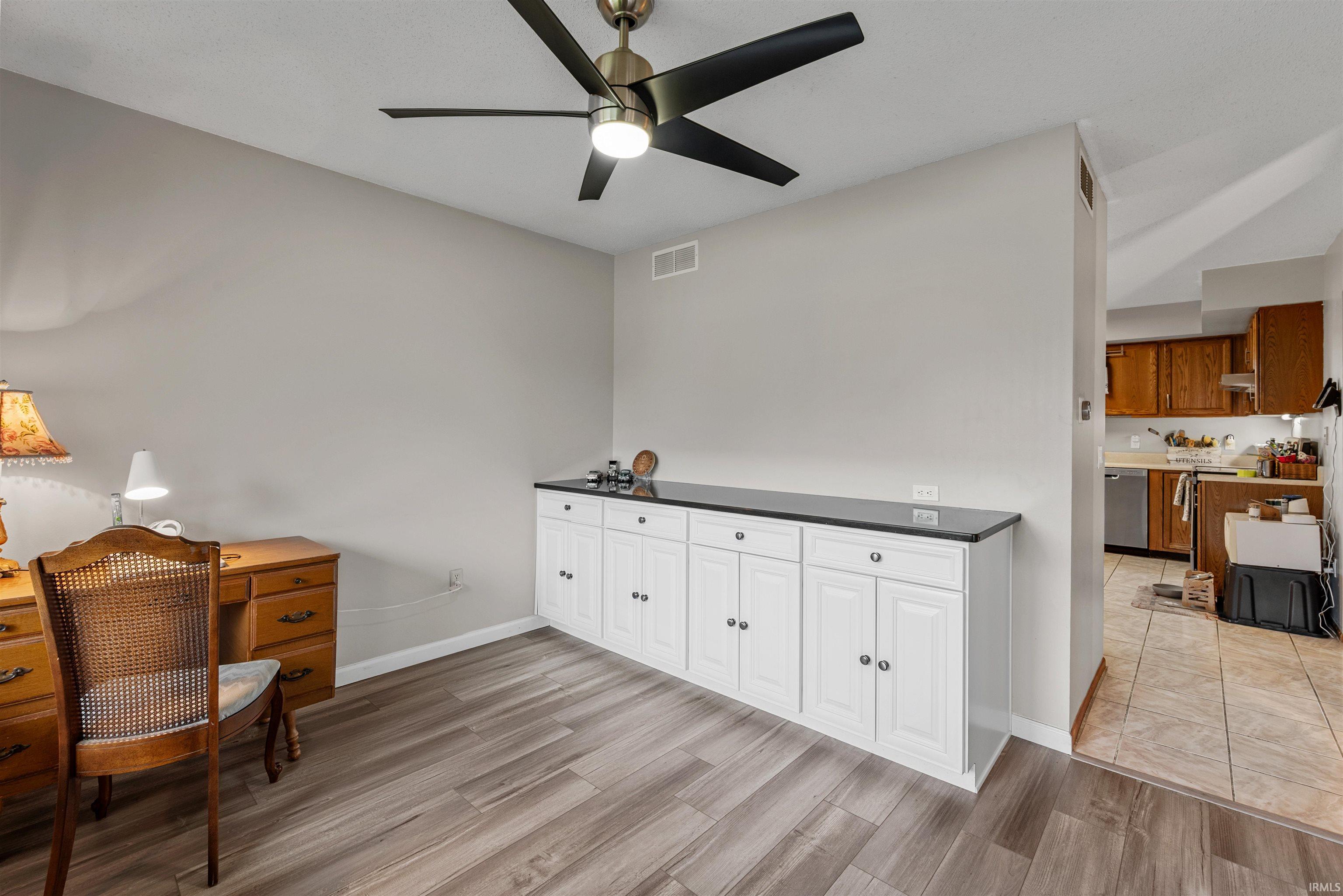 Built-in white cabinetry with a dark countertop provides extensive storage
