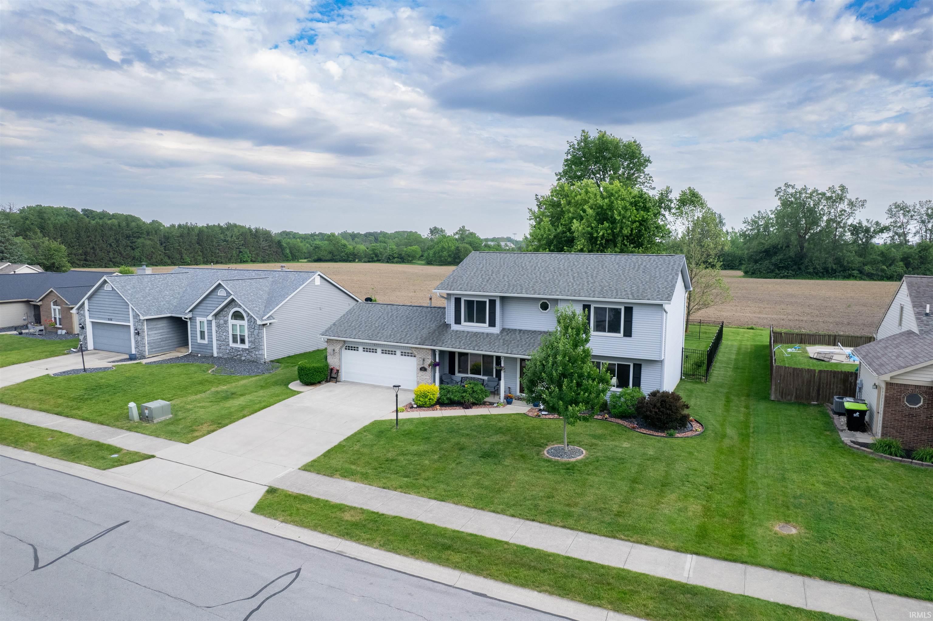Two-story residence featuring light gray siding, dark shutters, and a gray shingle roof