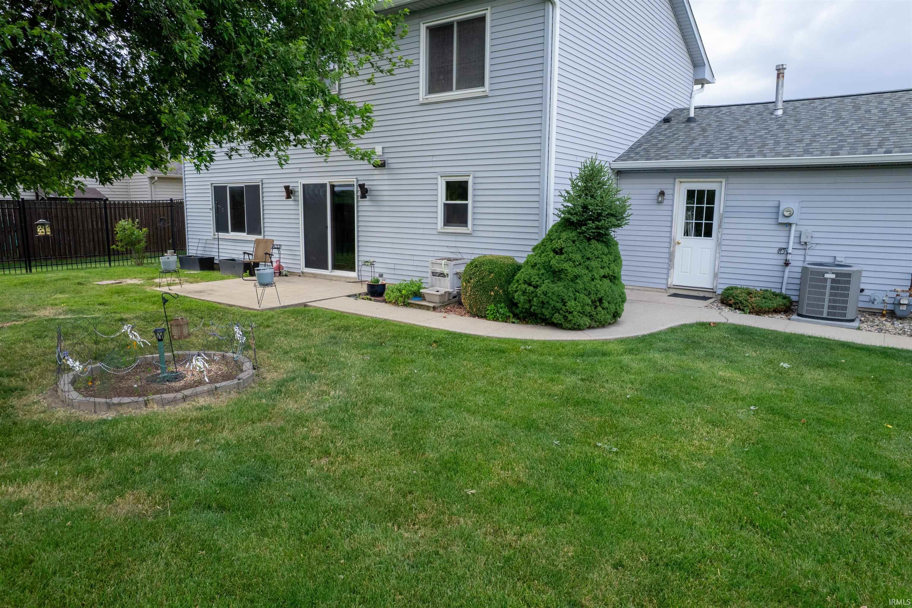 Expansive green lawn with a concrete patio and walkway