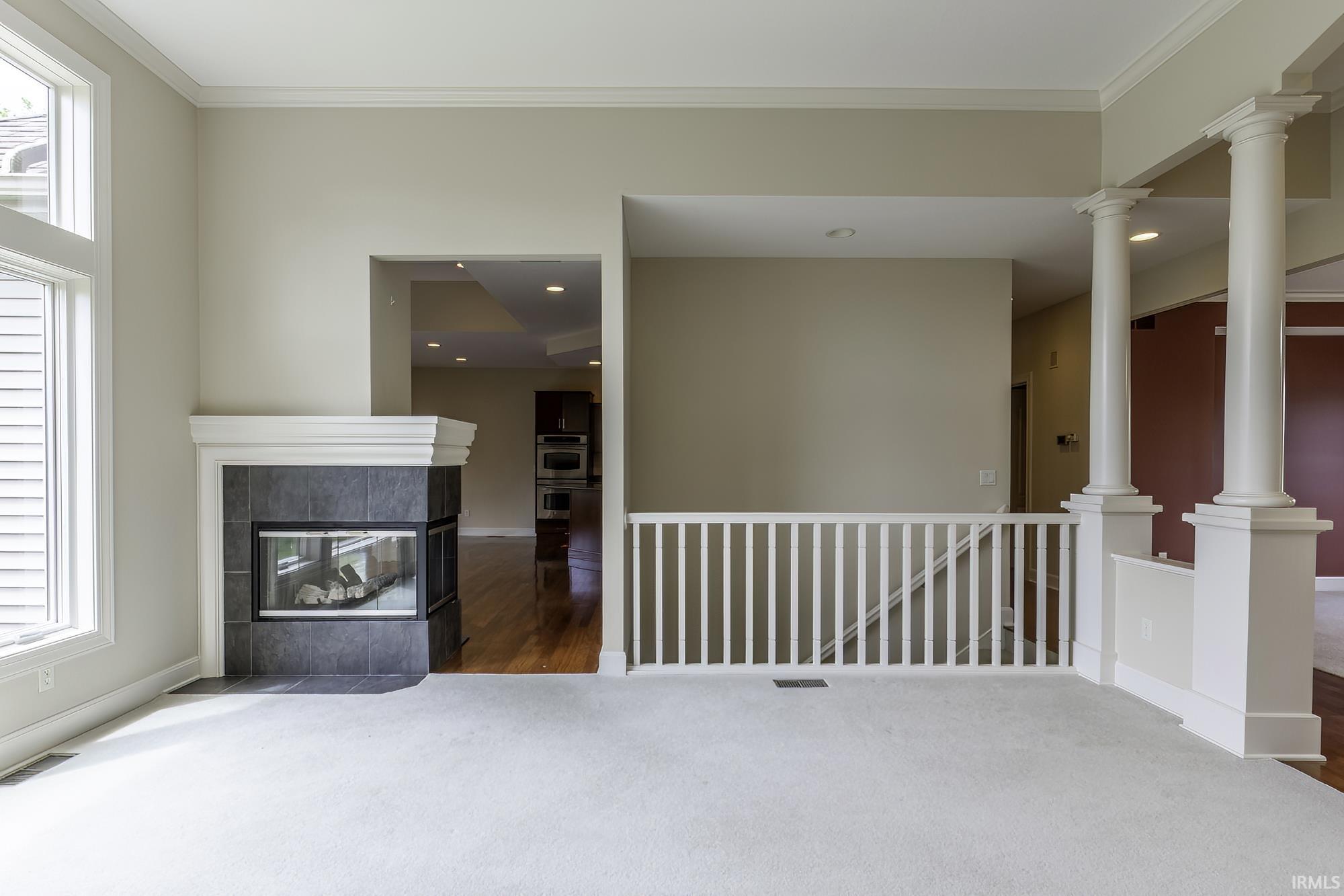 Living area featuring a contemporary corner fireplace with a dark tile surround and white mantel