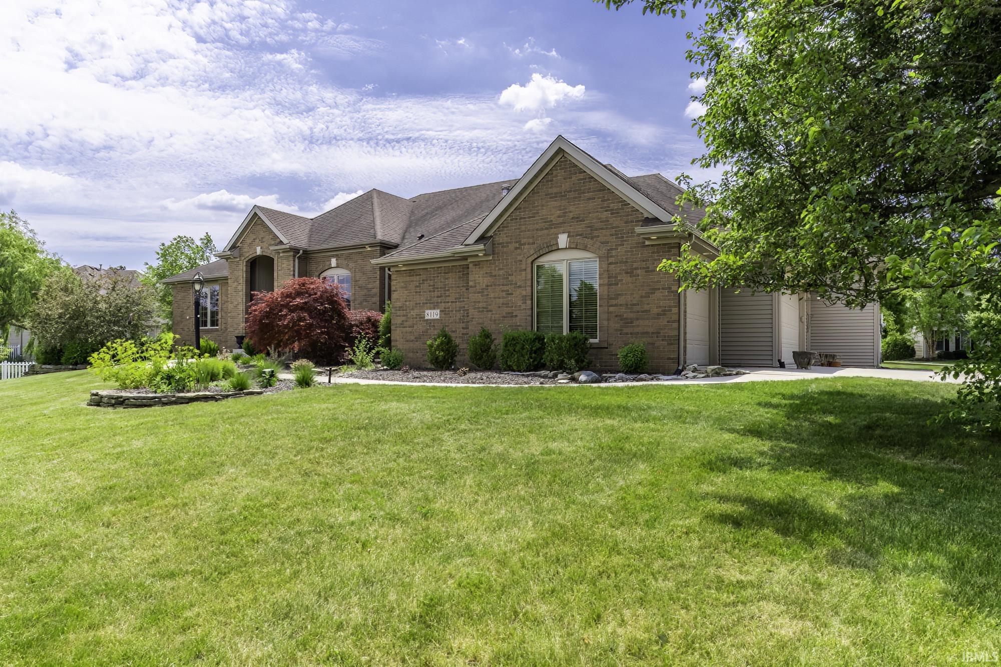 Brick exterior residence with an arched entry and multiple gabled rooflines