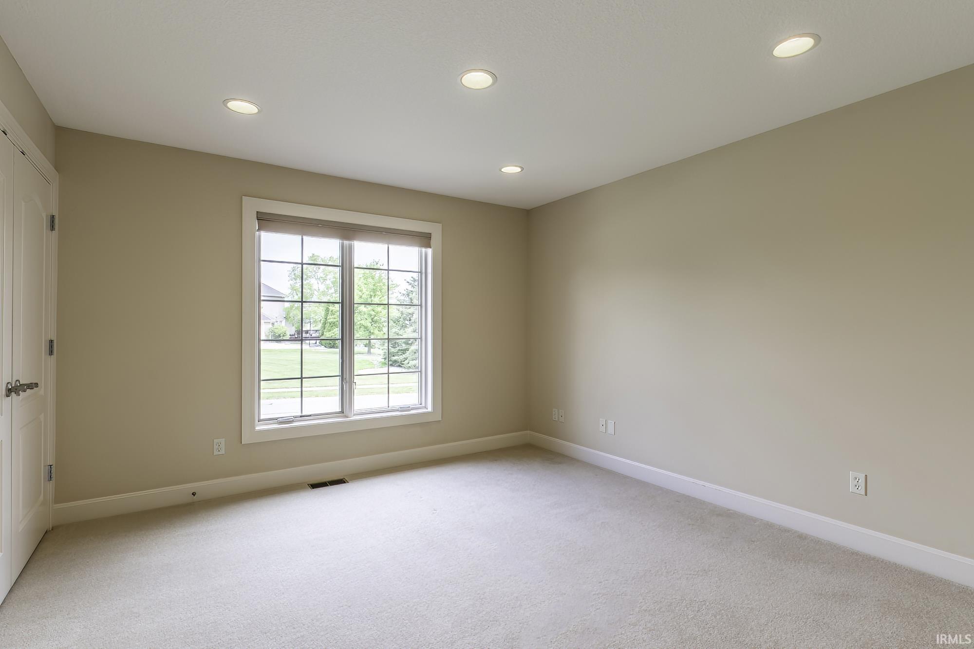 Neutral-toned carpeting paired with recessed ceiling lighting