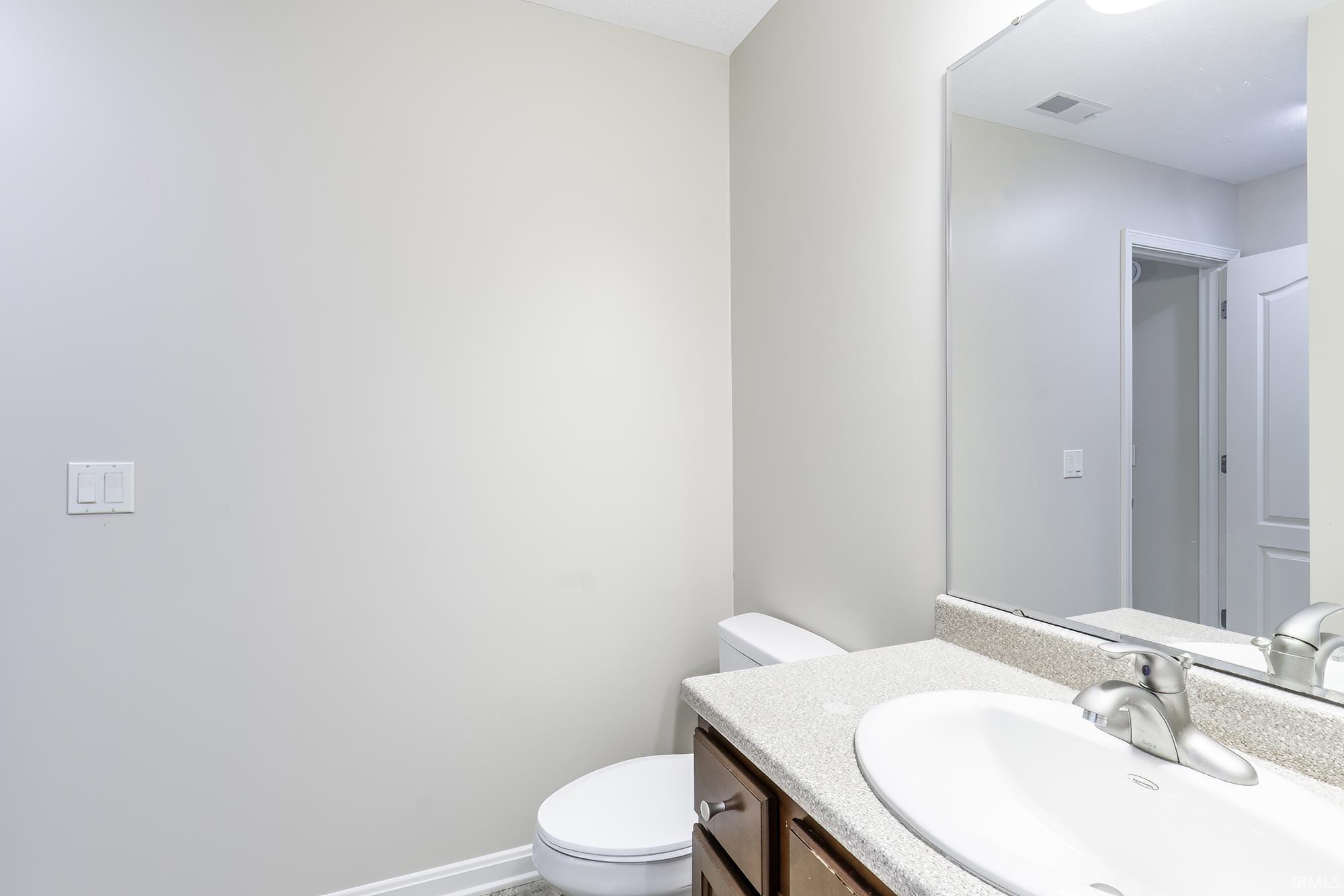 Bathroom vanity featuring a speckled countertop, integrated sink, and brushed nickel faucet