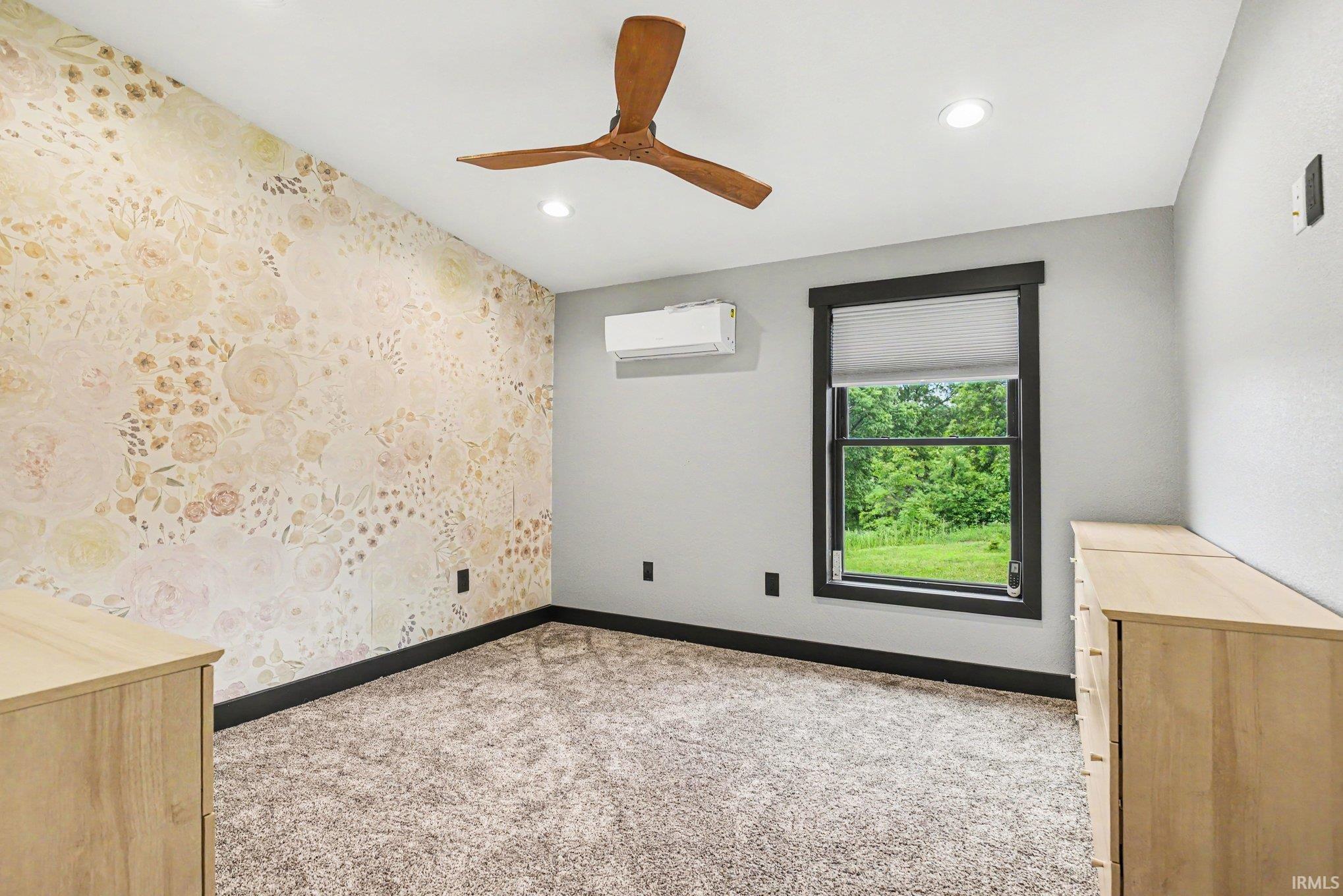 Bedroom featuring a decorative accent wall, recessed ceiling lighting, and a wood-finish ceiling fan
