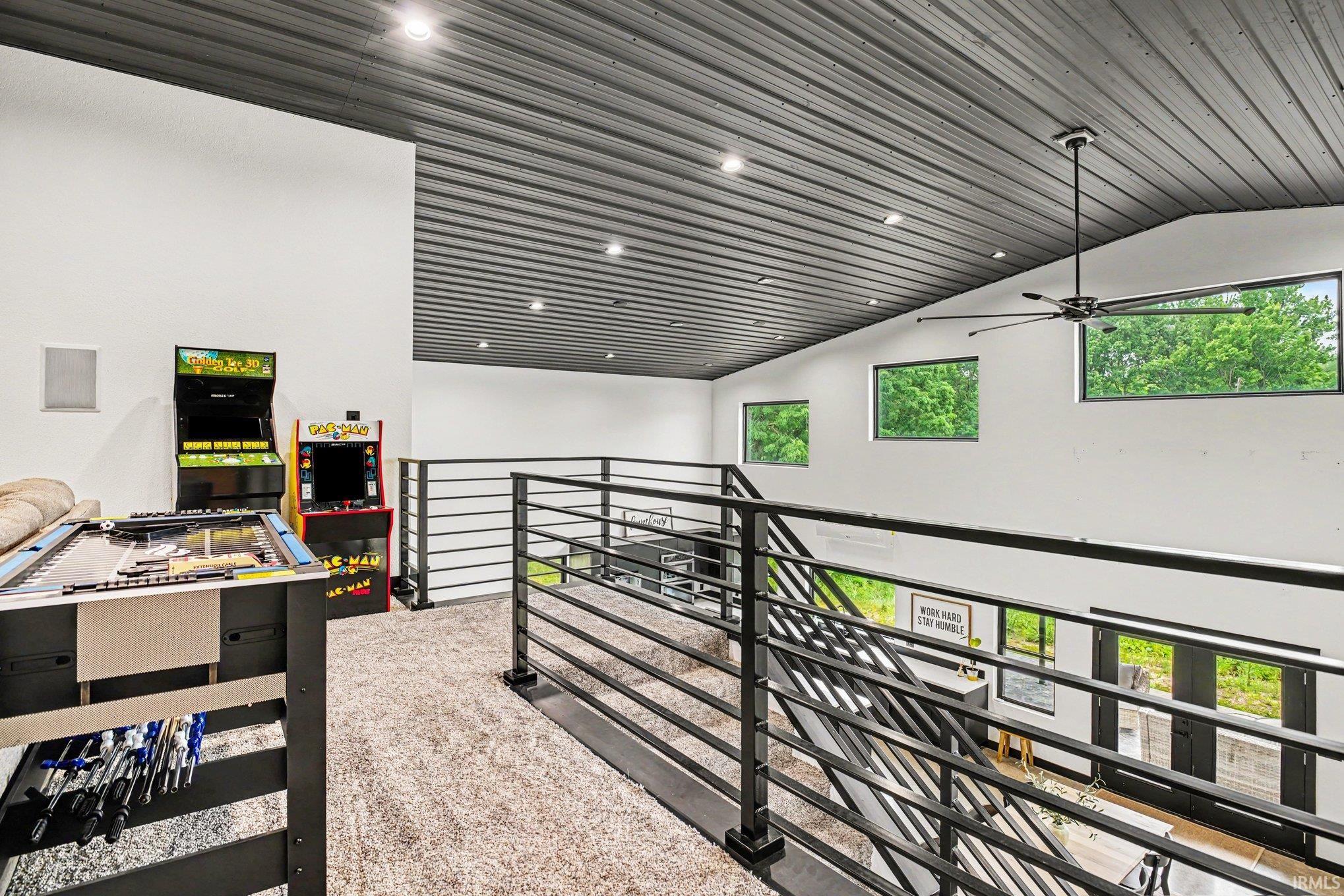 Expansive loft space featuring a corrugated metal ceiling and recessed lighting