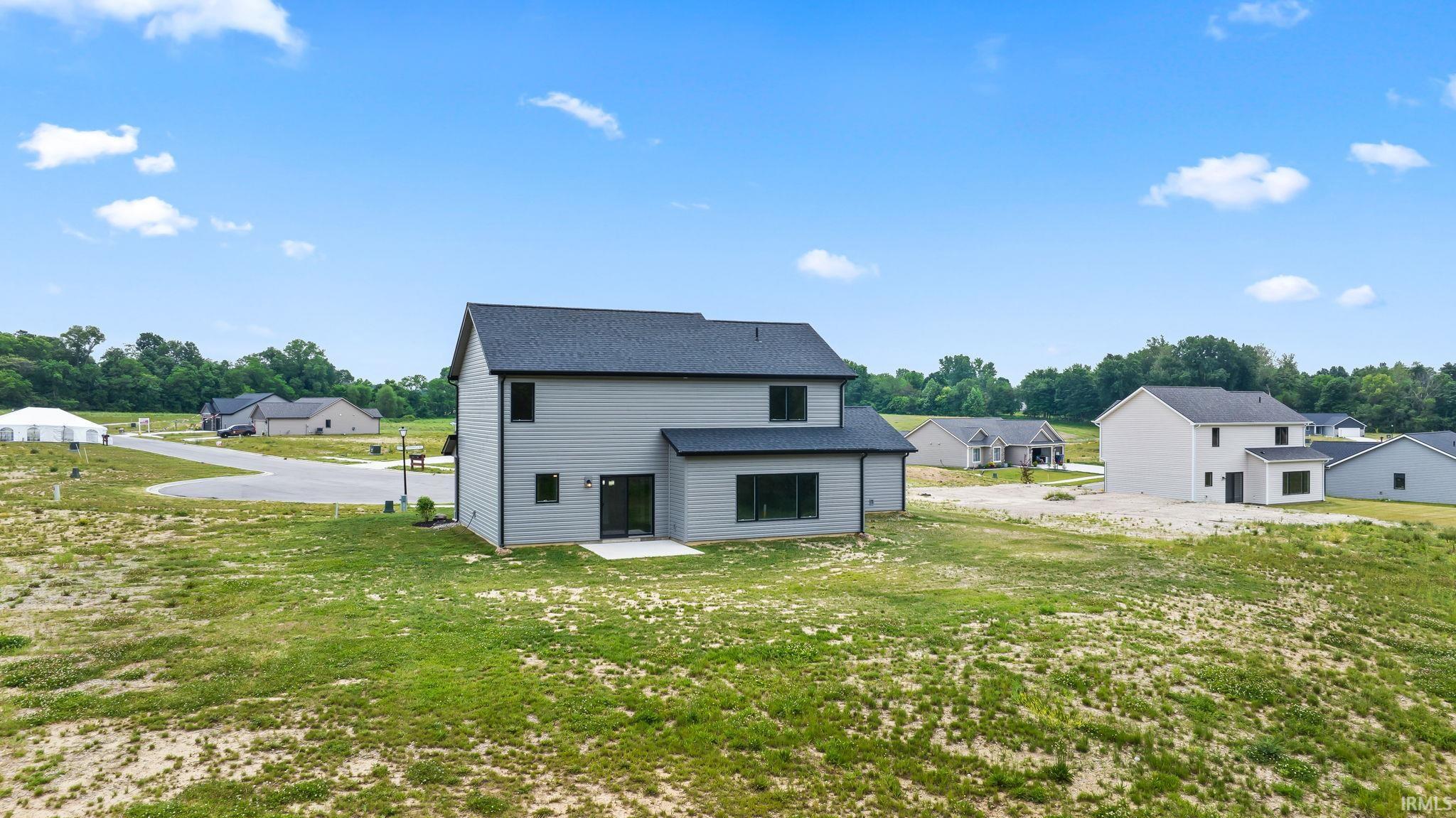 Newly constructed residence featuring light gray siding and a dark gray shingle roof