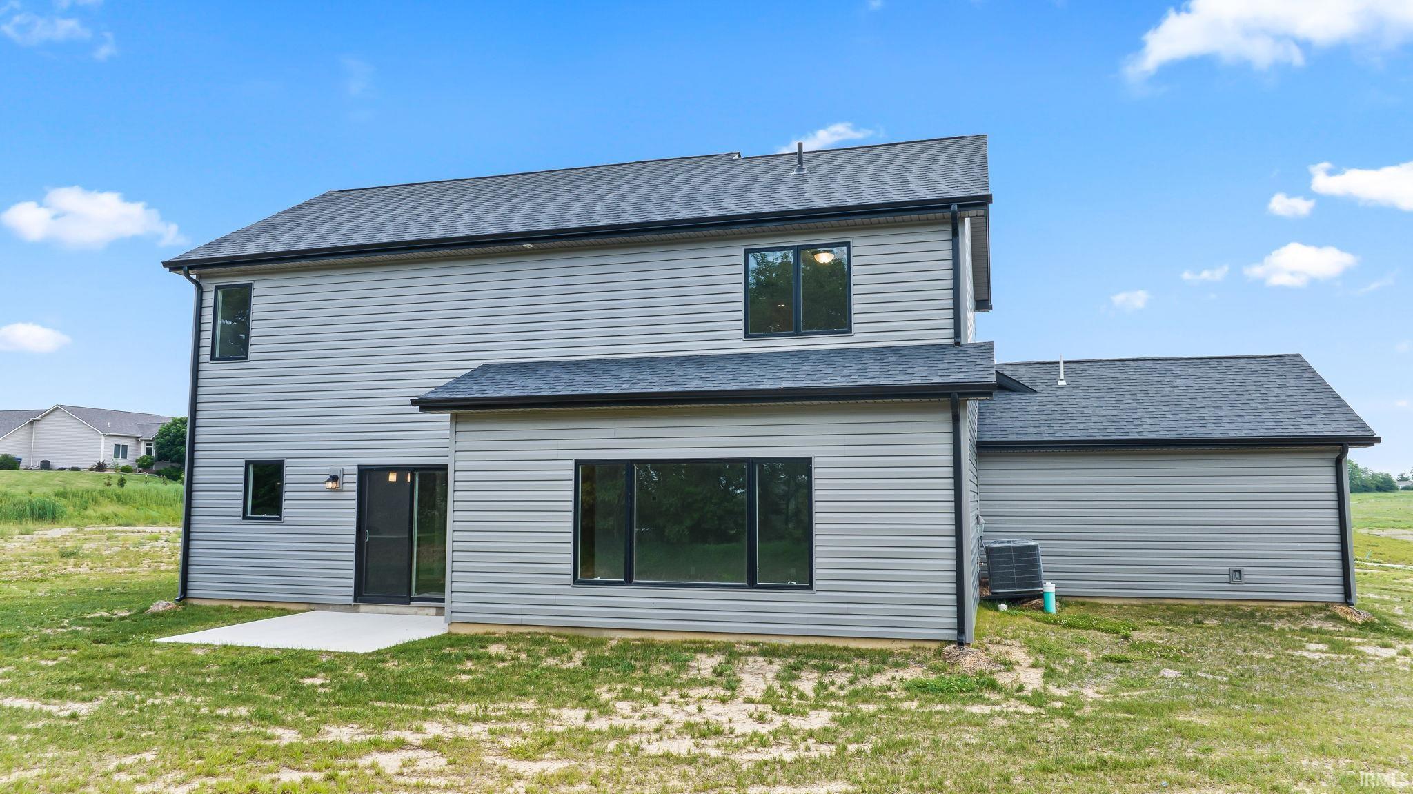 Contemporary rear exterior featuring grey horizontal siding and a dark shingle roof
