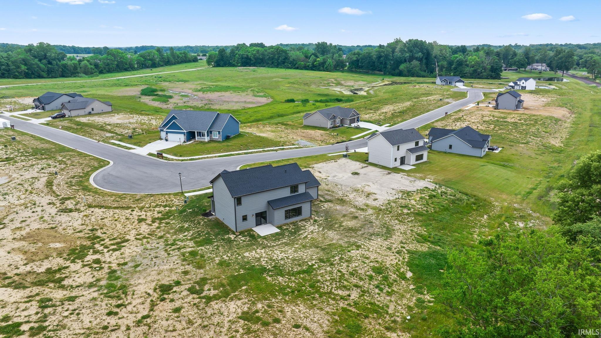 New construction homes within a developing community, featuring varying architectural styles and paved cul-de-sac streets