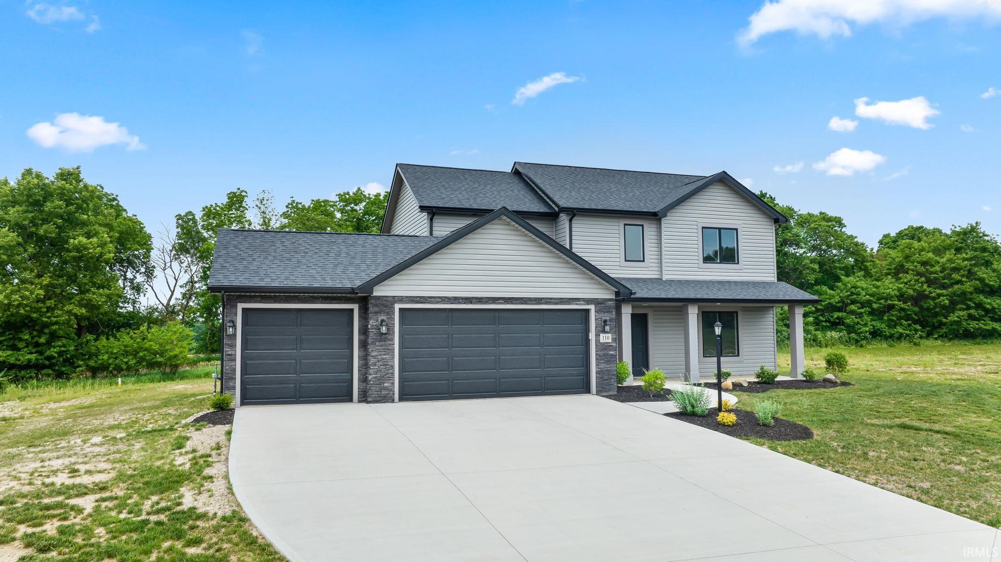 Contemporary two-story residence featuring light gray siding and dark gray stone accents