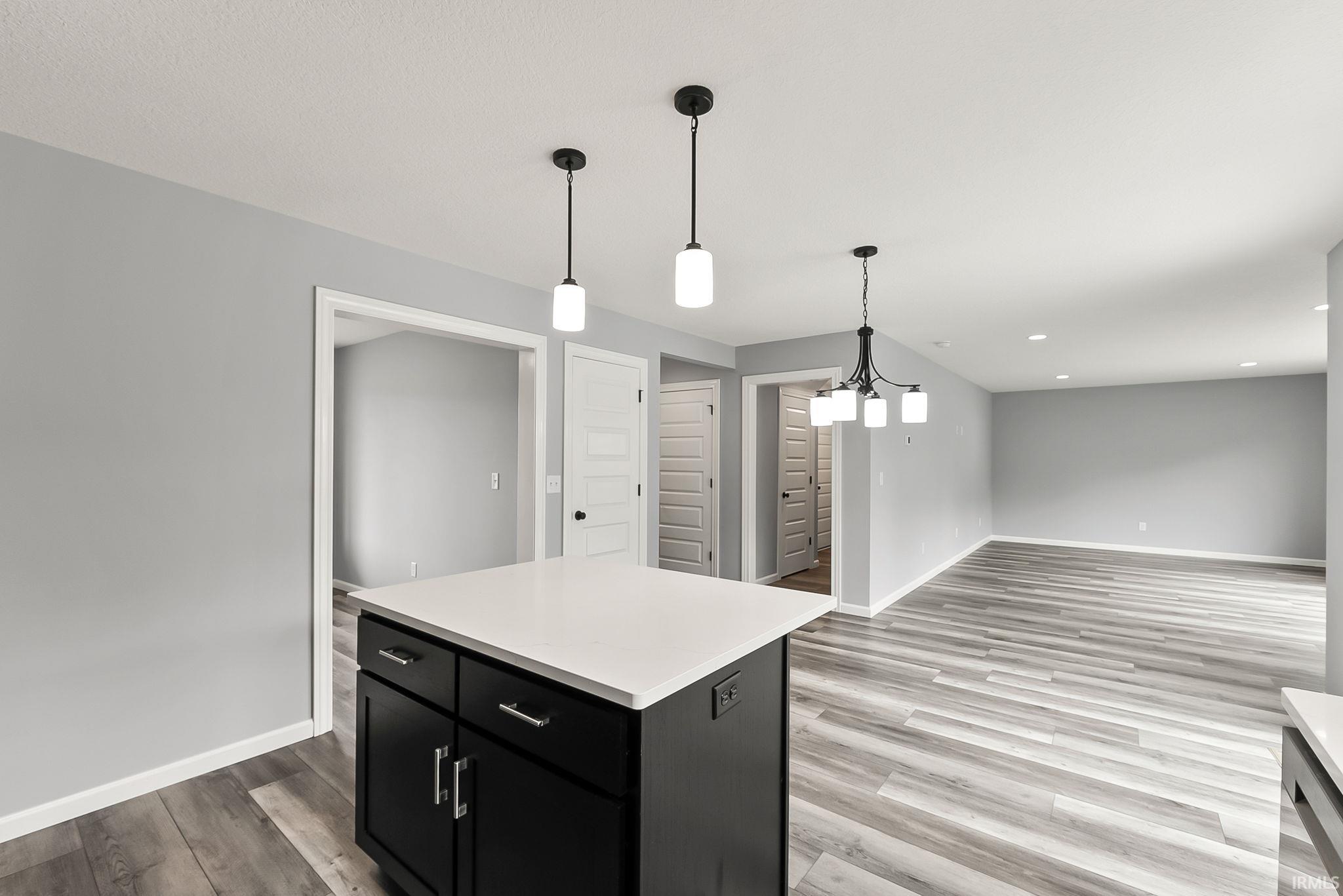 Kitchen island with a white countertop and dark cabinetry