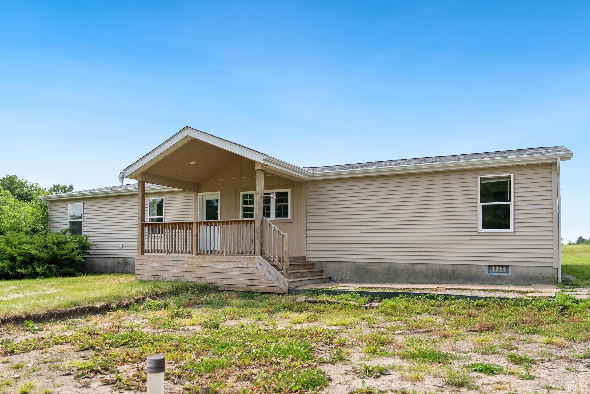 Exterior elevation featuring light-toned horizontal siding and a covered front porch
