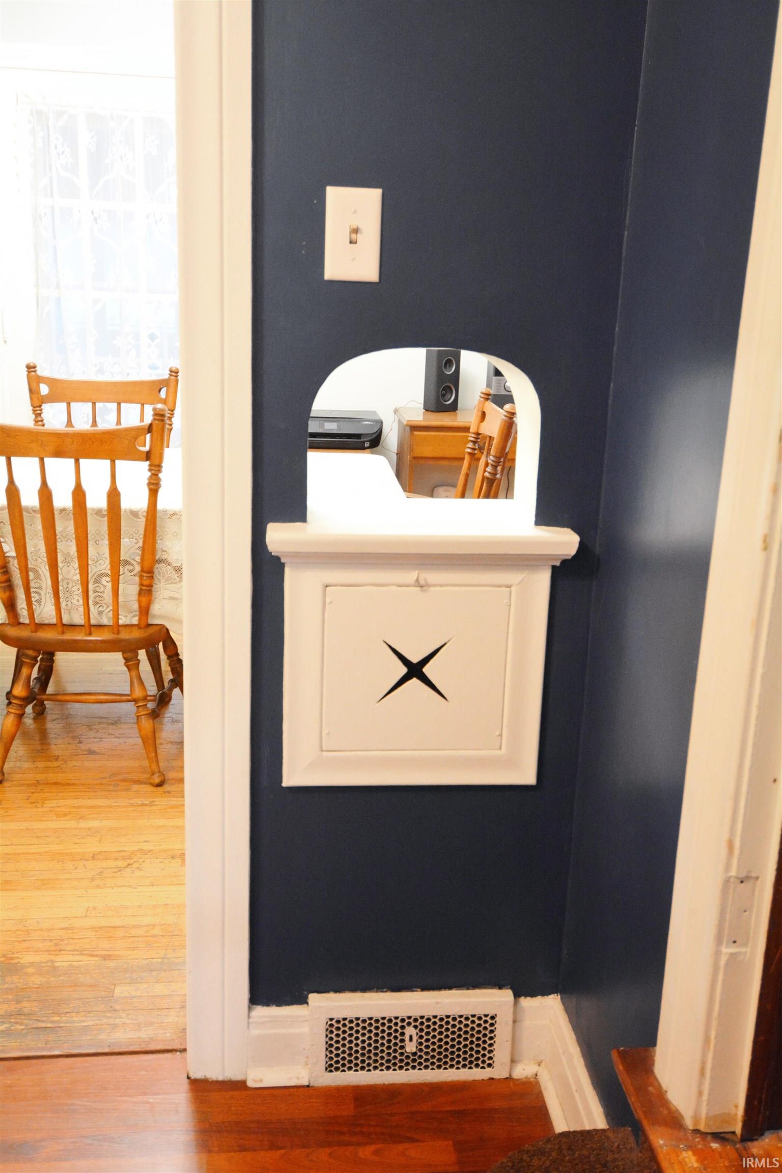 Pass-through window with a decorative shelf, white trim, and a wall-mounted light switch