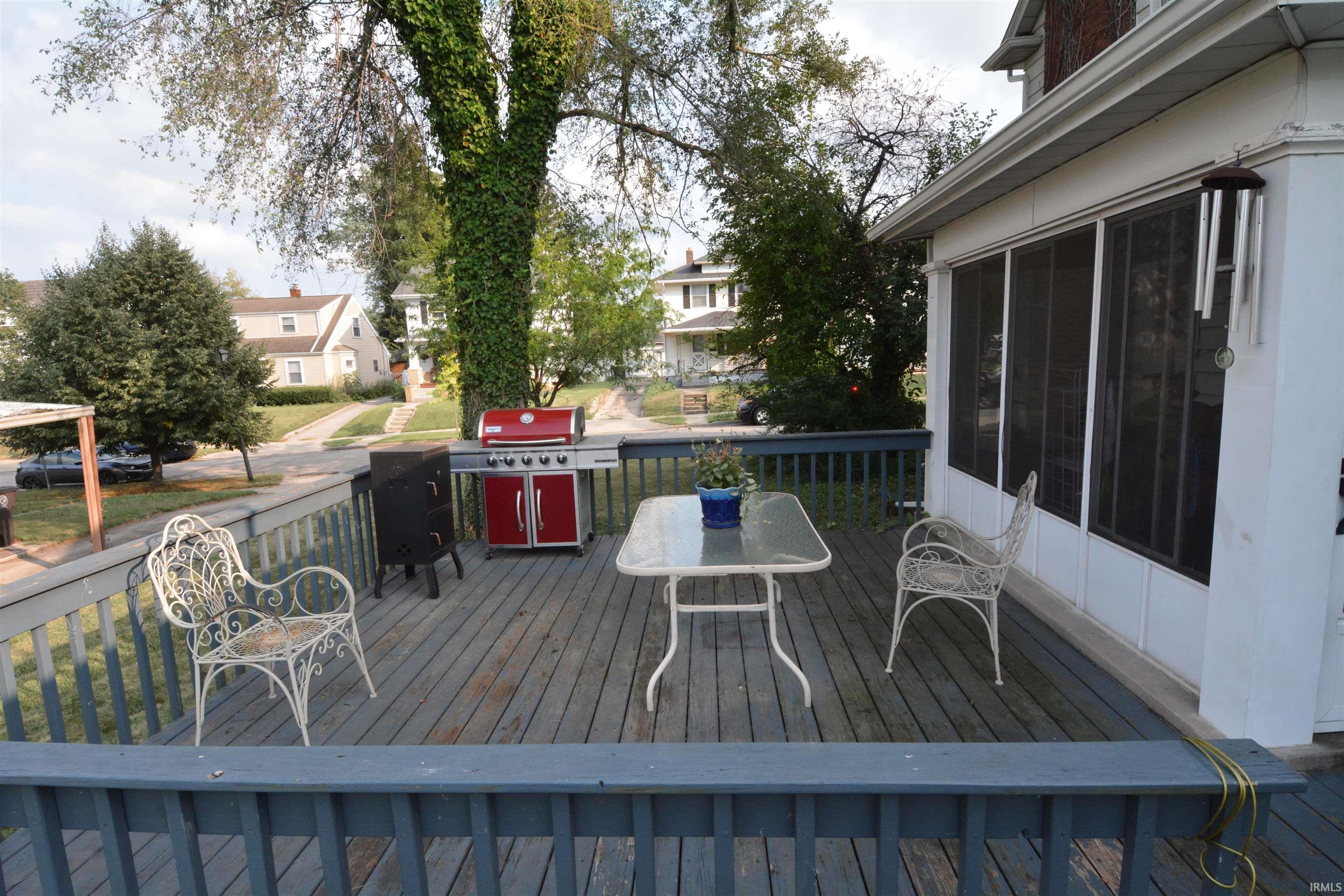 Expansive outdoor deck featuring wood-finish flooring and a partial railing