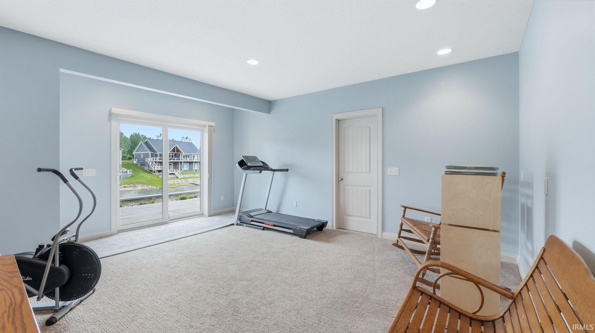 Spacious room with light blue walls and neutral carpeting