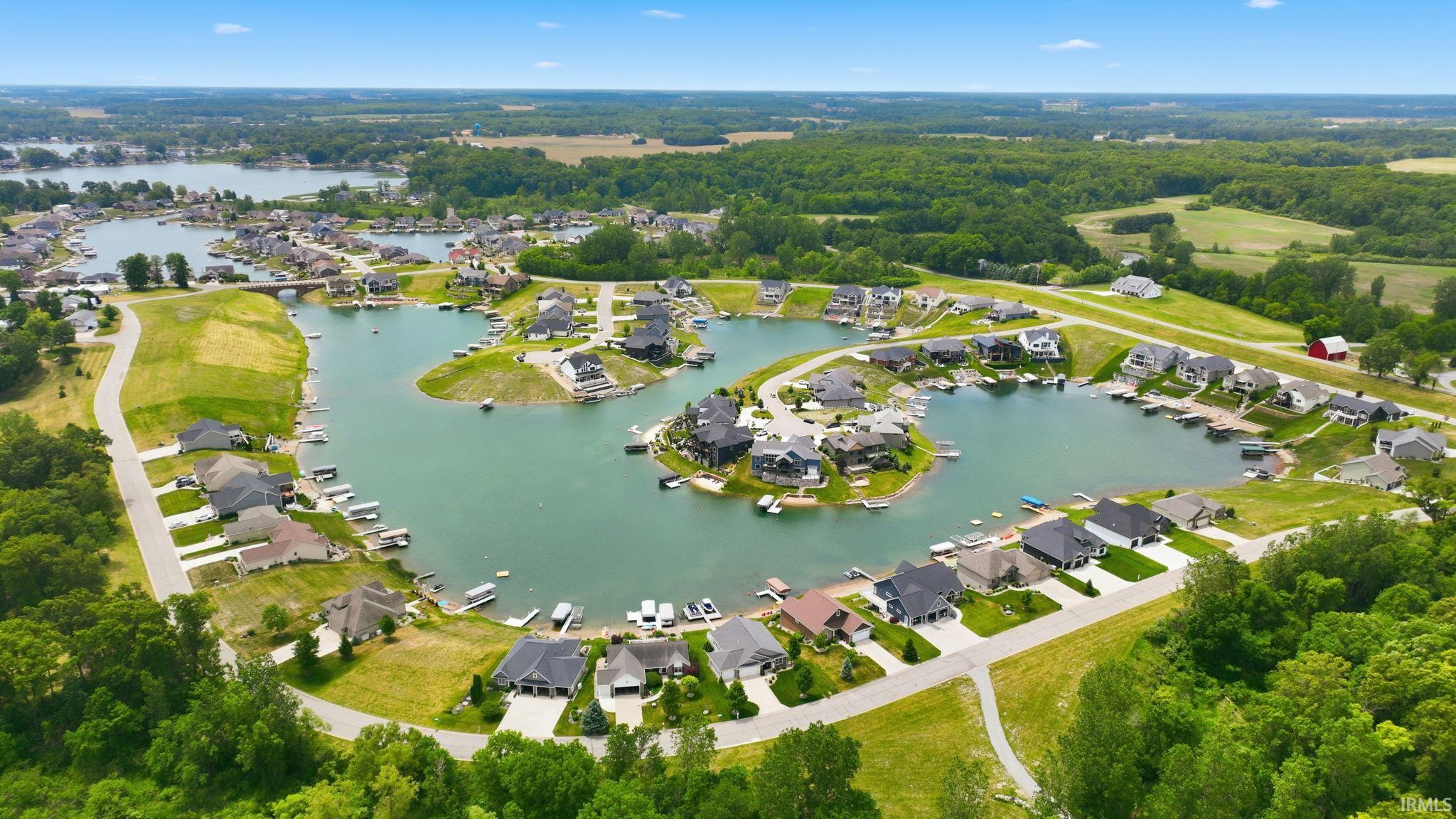 Waterfront community with homes featuring private docks, surrounded by expansive green spaces and mature trees