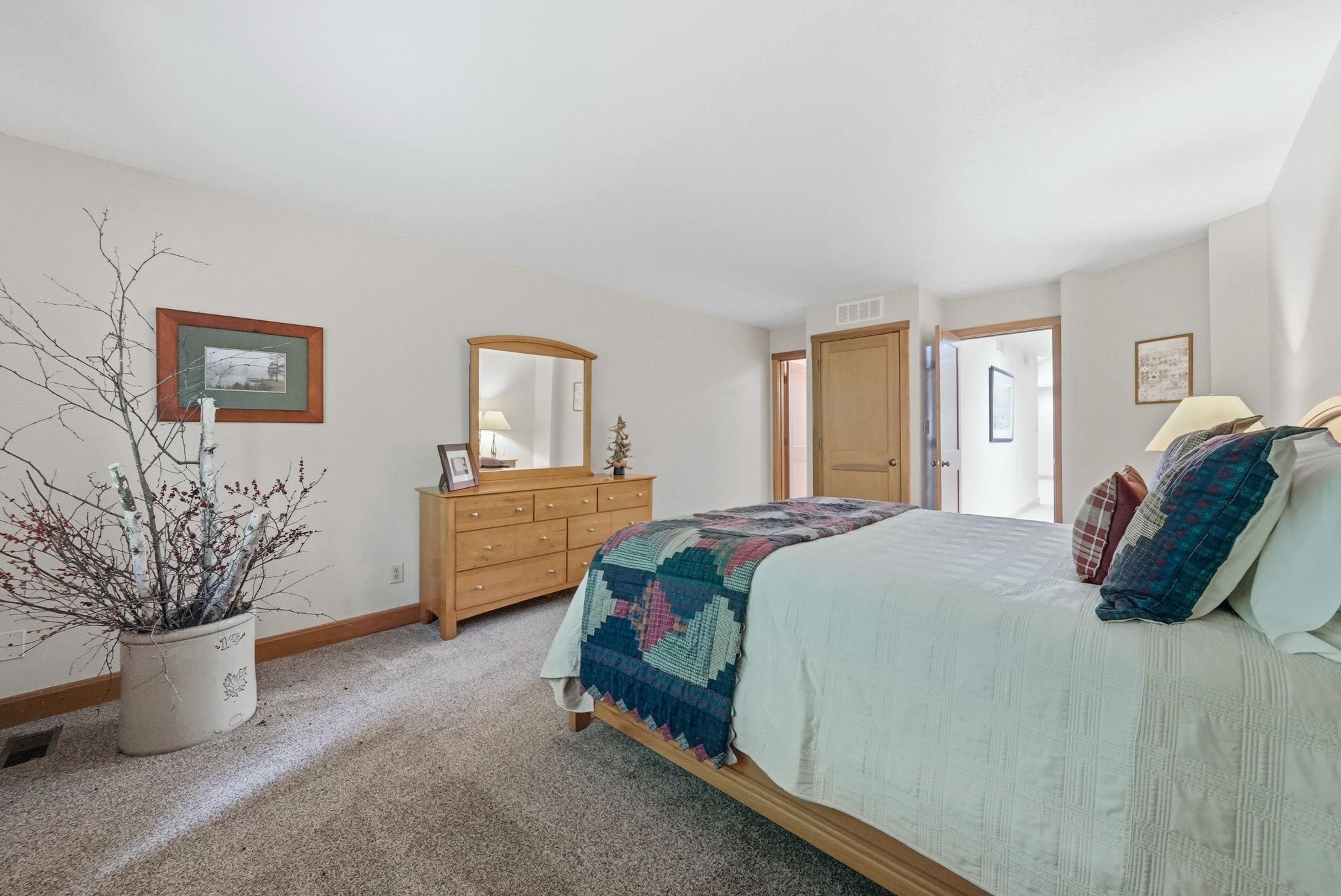 Carpeted bedroom with neutral wall tones, wood trim, and solid wood doors