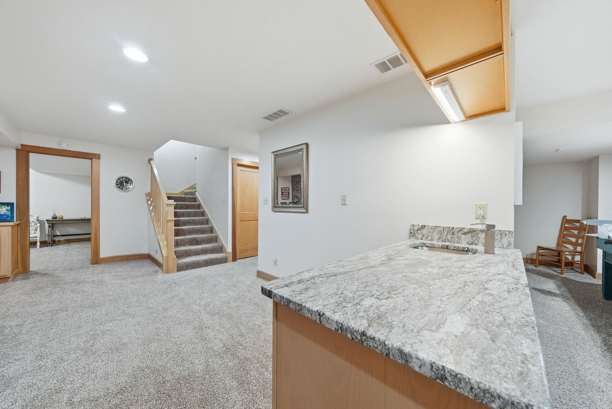 Wet bar with a light-toned countertop and an undermount sink