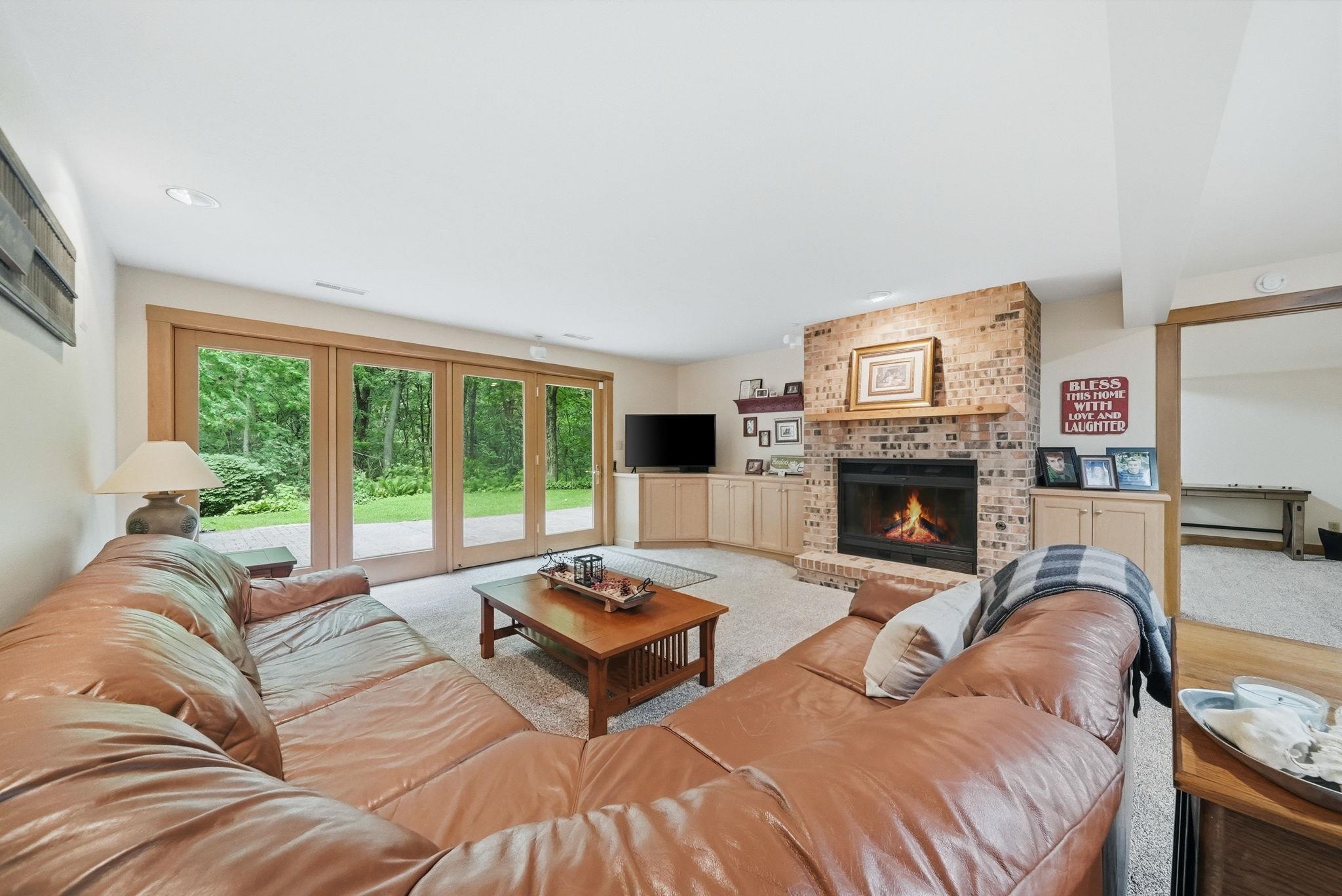 Living area featuring a brick fireplace with wood mantel, built-in cabinetry, and large sliding glass doors opening to outdoor space