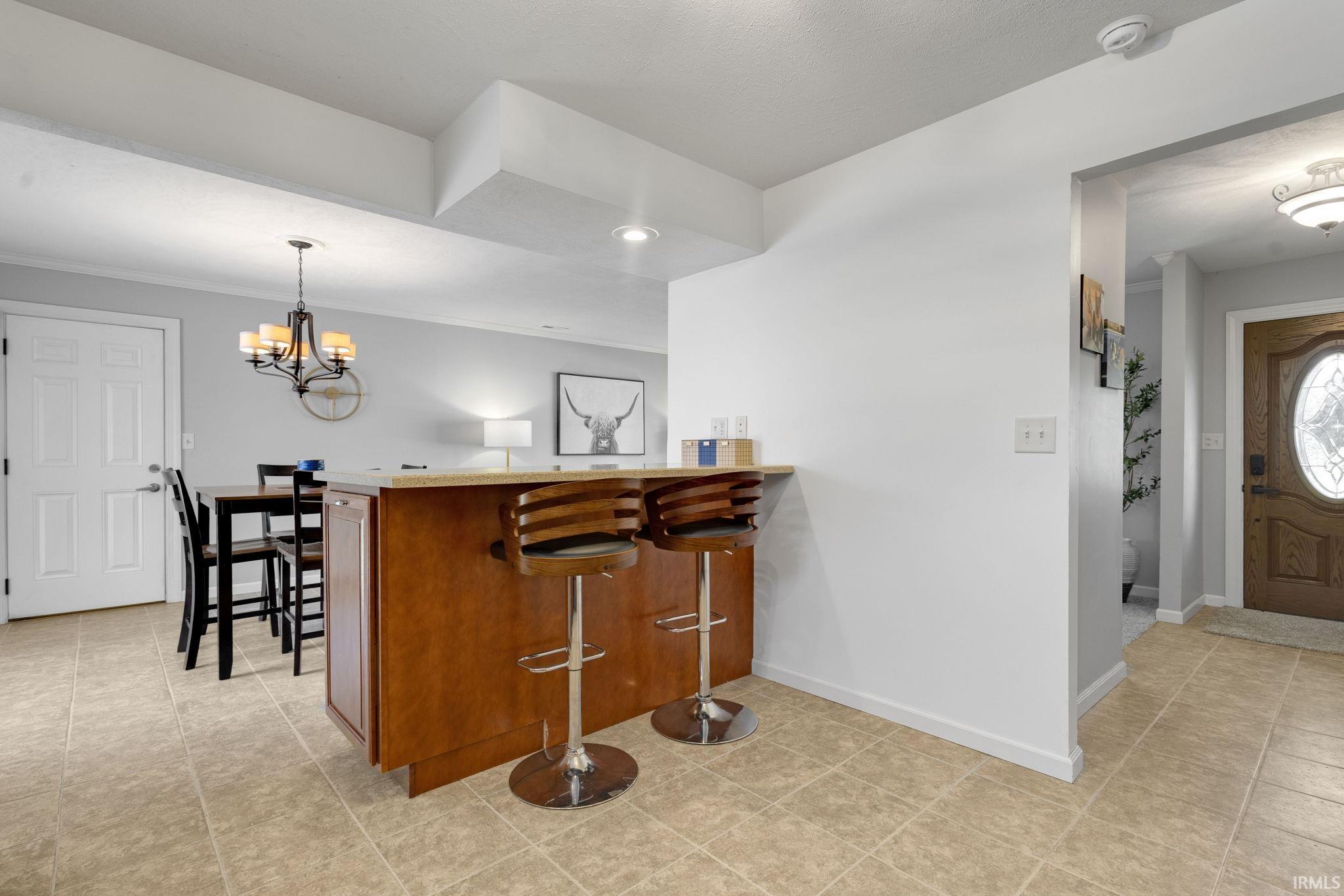 Breakfast bar with wood-finish cabinetry and a light-toned countertop