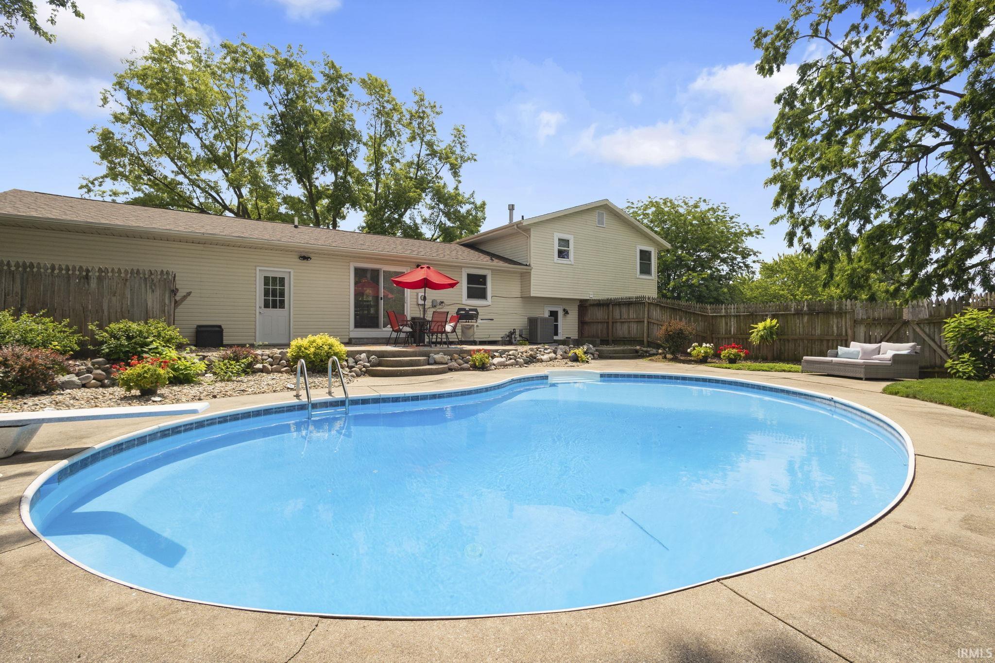 Curved inground pool with concrete surround